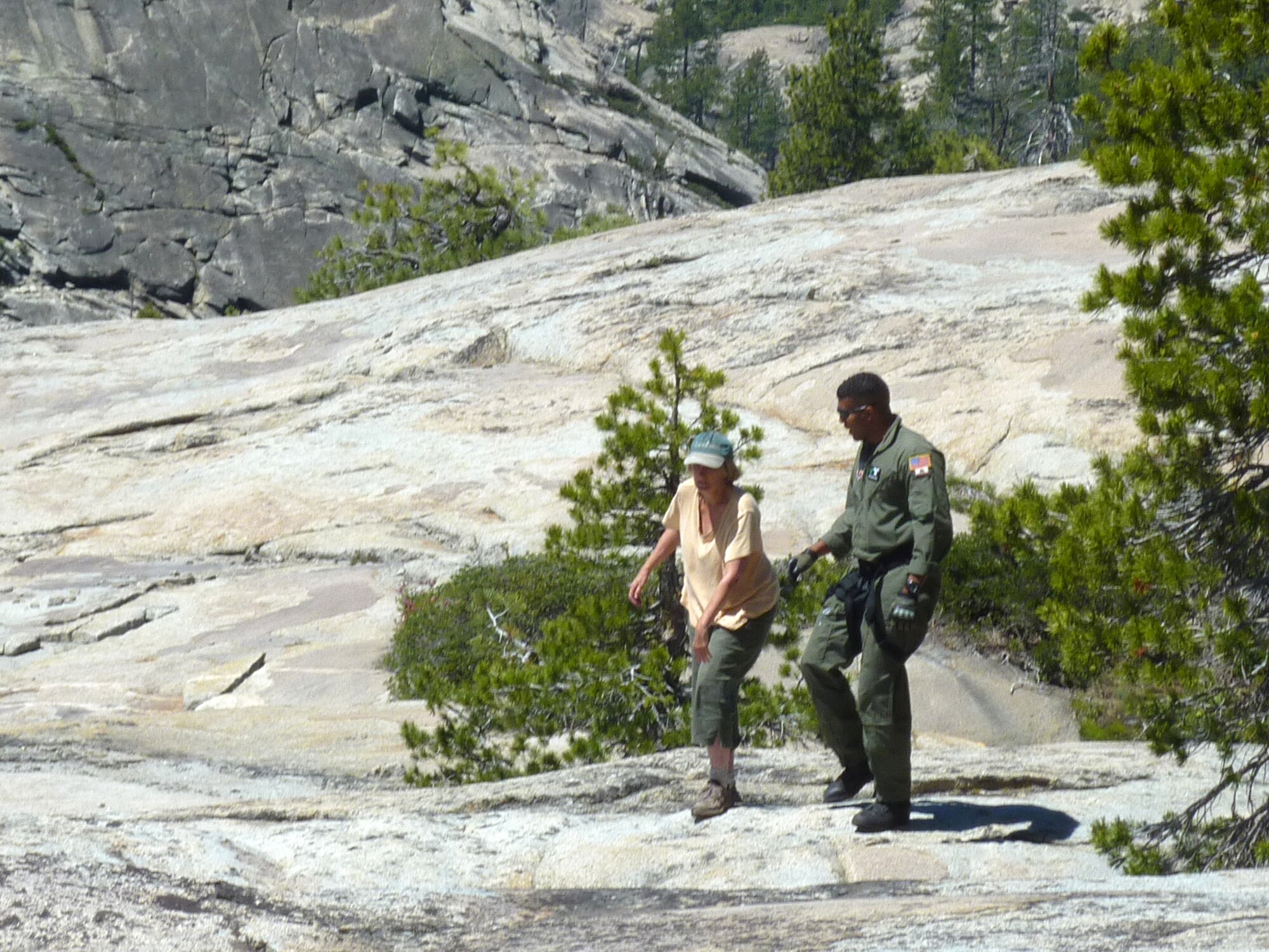 Senior Airman Edward Drew assists a hiker during a rescue mission in El Dorado National Forest, Calif., July 4, 2011.  An aircrew from the 129th Rescue Wing rescued the hiker after she was missing for nearly 48 hours.  (California Air National Guard photo by Staff Sgt. Andrew Gibson)