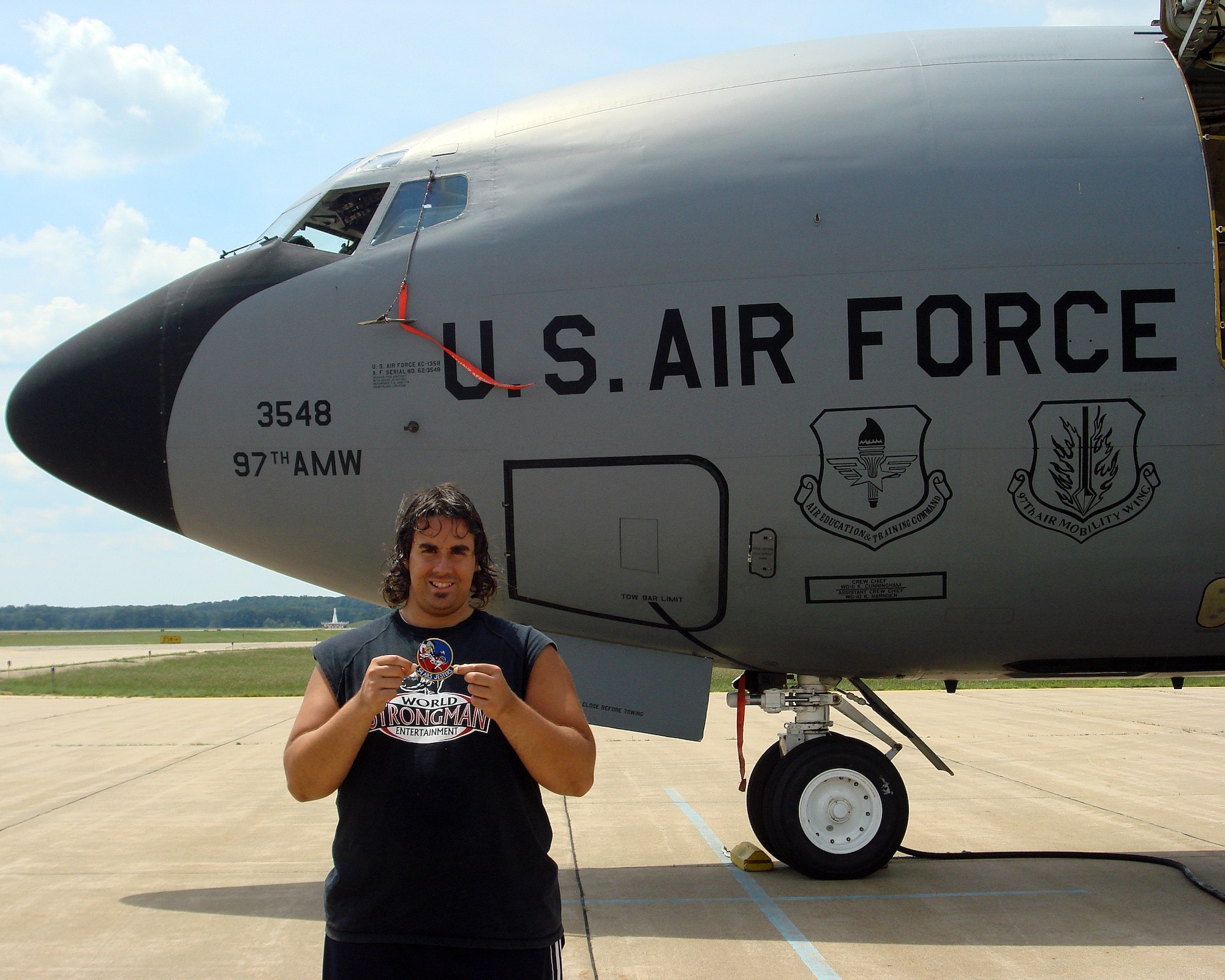 Battle Creek, Mich. -- Strongman Mark Kirsch holds a 54th Air Refueling Squadron patch while standing in front of a KC-135 Stratotanker from Altus Air Force Base during the Battle Creek Air Show and Balloon Festival in Battle Creek, Mich. July 1-4, 2011. Kirsch pulled the 140,000 pound aircraft five times during the air show. (U.S. Air Force Photo by Tech. Sgt. Phil Landram, 54th Air Refueling Squadron/ Released / 97th Air Mobility Wing Public Affairs)