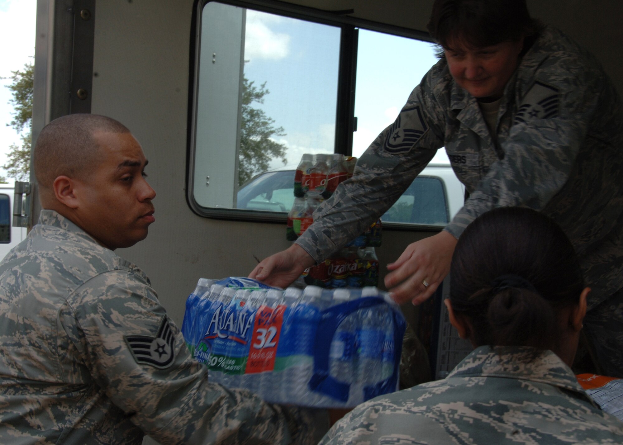 Master Sgt. Patricia Rodgers passes a case of water to Staff Sgt. Richard Rijos June 28, 2011 at Wilford Hall Medical Center deployment dock, Lackland Air Force Base, Texas. Food and water was generously donated by the American Red Cross in support of the new 59th Contingency Aeromedical Staging Facility located here. Sergeant Rodgers is the Surgical Speciality flight chief and Sergeant Rijos is a medical technician, both assigned to the 59th Inpatient Operations Group. (U.S. Air Force Photo/Senior Airman Kevin Iinuma)