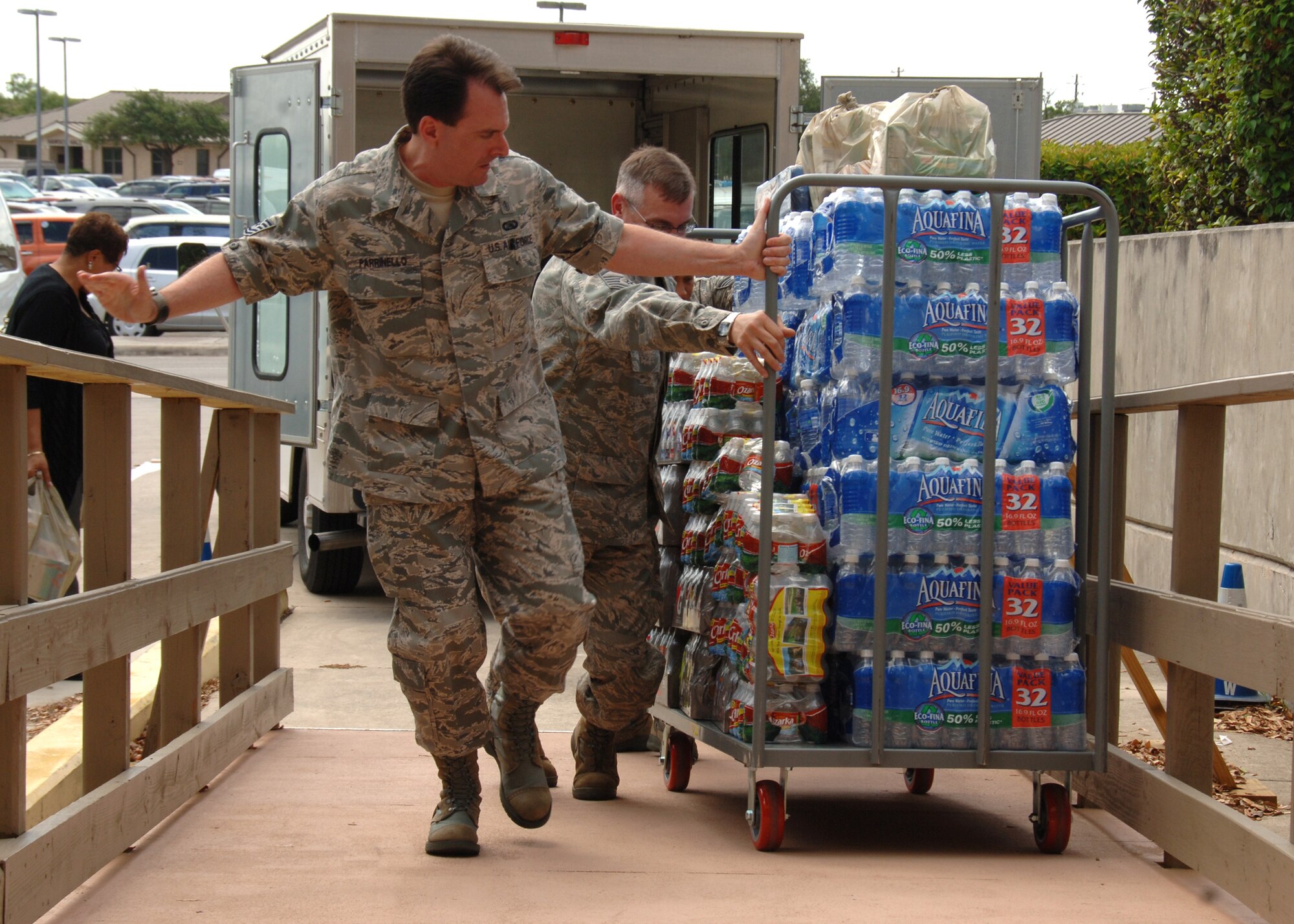 Tech Sgt. Paul Parrinello helps fellow Airmen pull a cart full of water up a ramp June 28, 2011 at Wilford Hall Medical Center, Lackland Air Force Base, Texas. Sergeant Parrinello was one of many volunteers to help load and unload donated goods from the American Red Cross, USO, Wounded Warriors, Pennies from Heaven, Blue Star Moms of San Antonio, private donors and WHMC Volunteer Services in support of the new 59th Contingency Aeromedical Staging Facility here. Sergeant Parrinello is medical technician for the 59th Inpatient Operations Group.(U.S. Air Force Photo/  Senior Airman Kevin Iinuma)