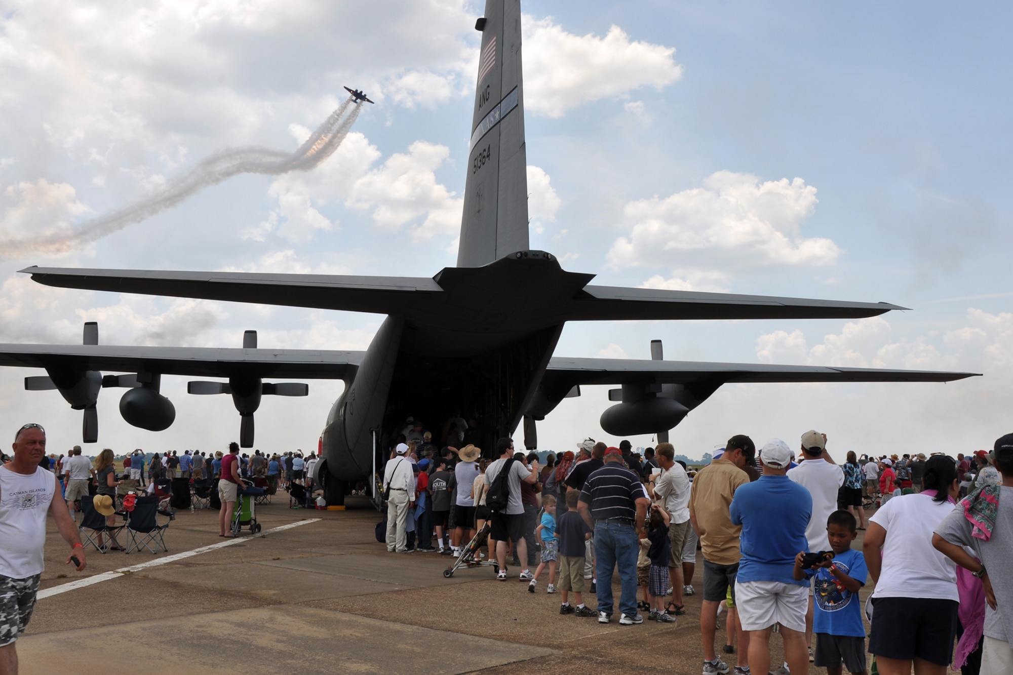 Spectators at the “Wings Over Tyler Air Show” get a tour of a Texas Air National Guard C-130 Hercules as Matt Younkin wows the audience while flying a Twin Beech 18 at the Tyler Pounds Regional Airport in Tyler, Texas, July 3, 2011. Although the Beech 18 was not designed for aerobatic flight, Younkin showed the crowd it could be done. (U.S. Air Force photo/Tech. Sgt. Jeff Walston)