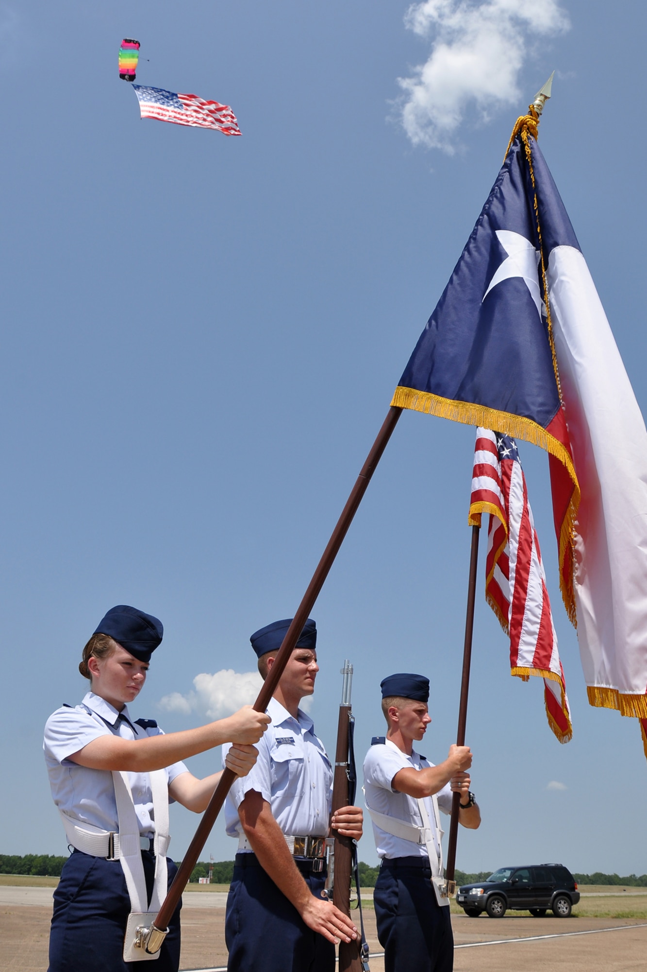 Members of the Civil Air Patrol, Tyler Composite Squadron, Tyler Texas, present the colors at the “Wings Over Tyler Air Show” as a parachutist makes his approach to the drop zone with an American Flag during opening ceremonies at Tyler Pounds Regional Airport, July 3, 2011. (L to R) Cadet 2nd Lt. Sarah Fitzgerald, Cadet Capt. James Schulgen and Cadet 2nd Lt. Joseph Hughes. (U.S. Air Force photo/Tech. Sgt. Jeff Walston)
