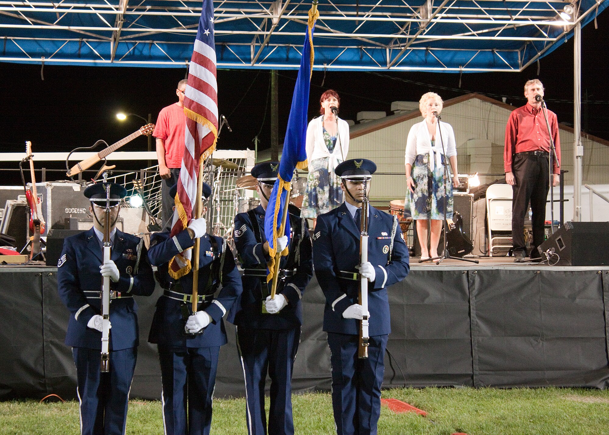 Members of the Edwards Color Guard present the colors in front of the stage during the singing of the National Anthem by singing quartet All That before the fireworks show at Summer Bash 2011. (Air Force photo by Jet Fabara)