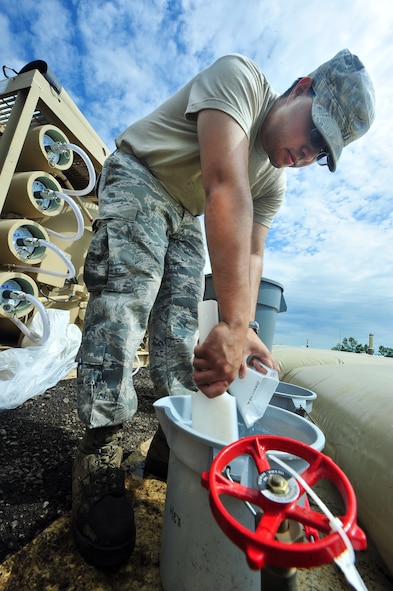 MINOT AIR FORCE BASE, N.D. -- Airman 1st Class Christopher Martinez, 5th Civil Engineer Squadron waters fuels maintenance apprentice, works on the recently acquired reverse osmosis water purification units brought here from Holloman Air Force Base, N.M., July 5. In order to ensure the continuation of water supply throughout Minot Air Force Base, six reverse osmosis water purification units are fully functional and running, with an additional two units designated as reserve components. (U.S. Air Force photo/Senior Airman Jesse Lopez)