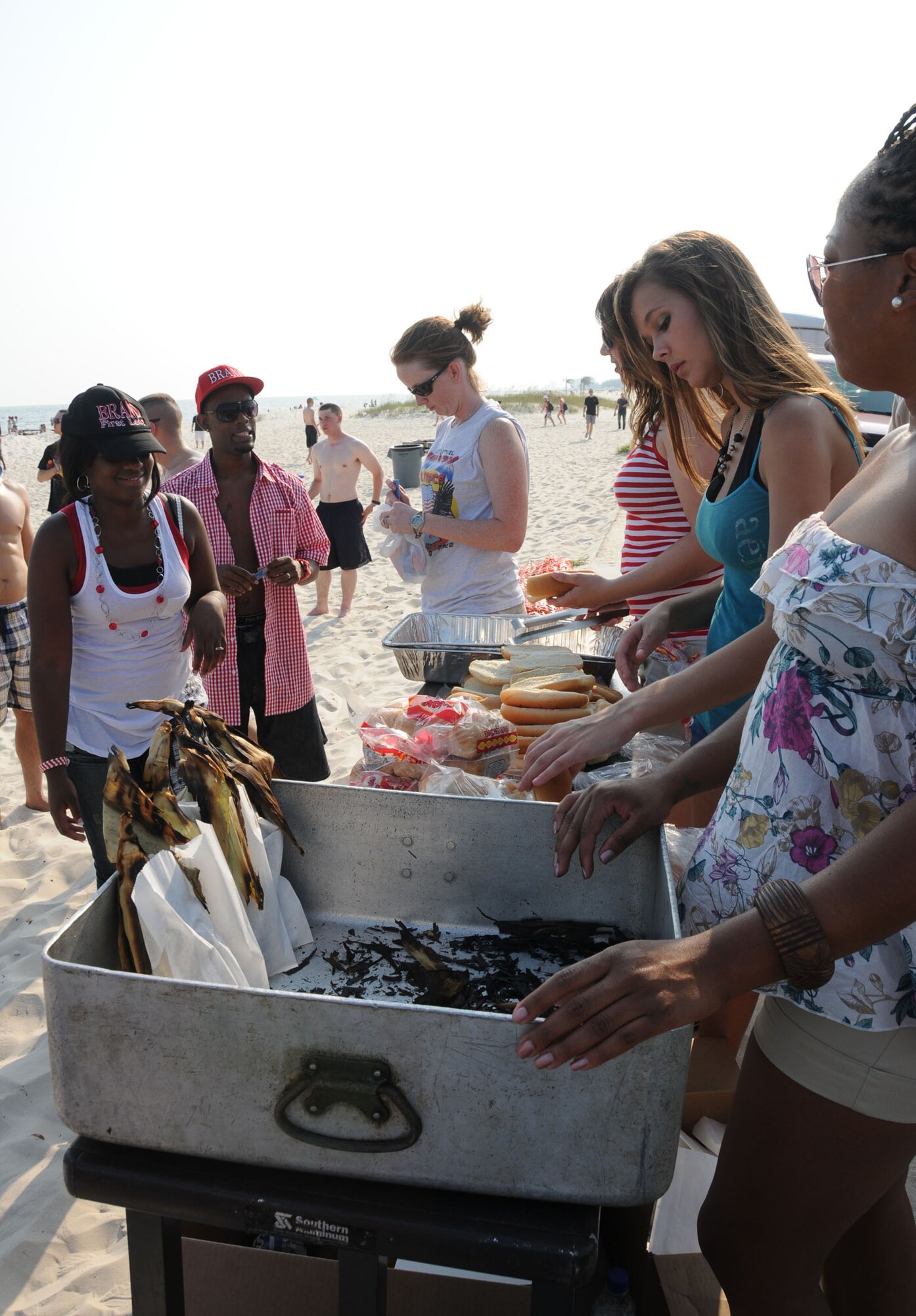 Staff Sgt. Sabine Bell, 81st Mission Support Group, and her husband Eddarious Bell, are served hot dogs, corn on the cob and bratwurst by Staff Sgt. Tawny Crutcher, 81st Training Wing, Staff Sgt. Elizabeth Aguirne, 81st Training Support Squadron, Ashlee Goff, age 16 and Tech. Sgt. Kim Sturdivant, 81st Contracting Squadron at Keesler's 4th of July Beach Bash.  Ashlee's parents are Wayne and Carrie Cox, 81st Force Support Squadron.  (U.S. Air Force photo by Kemberly Groue)