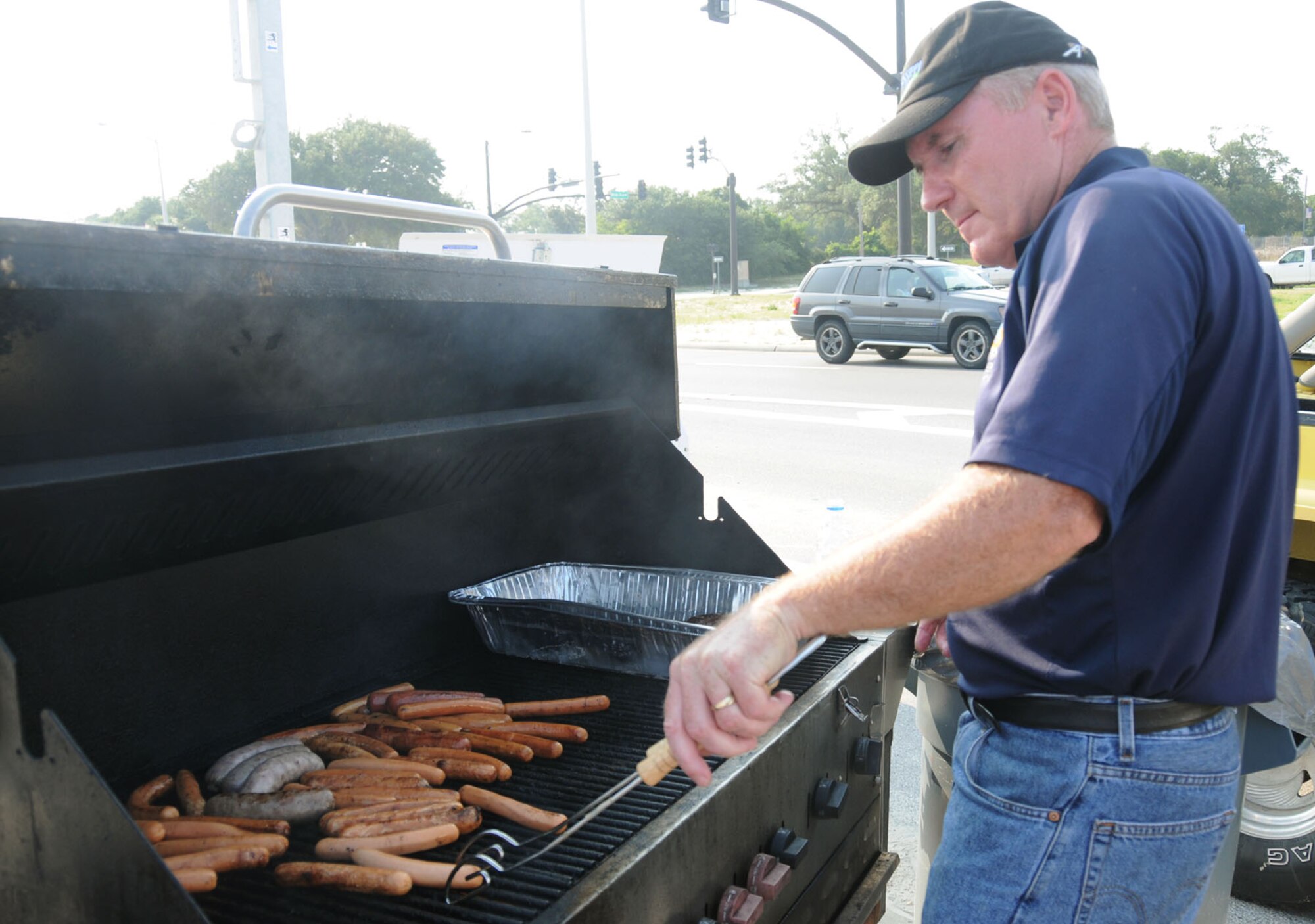 Tom Golden, 81st Force Support Squadron, grills hot dogs and bratwurst at Keesler's 4th of July Beach Bash.  (U.S. Air Force photo by Kemberly Groue)
