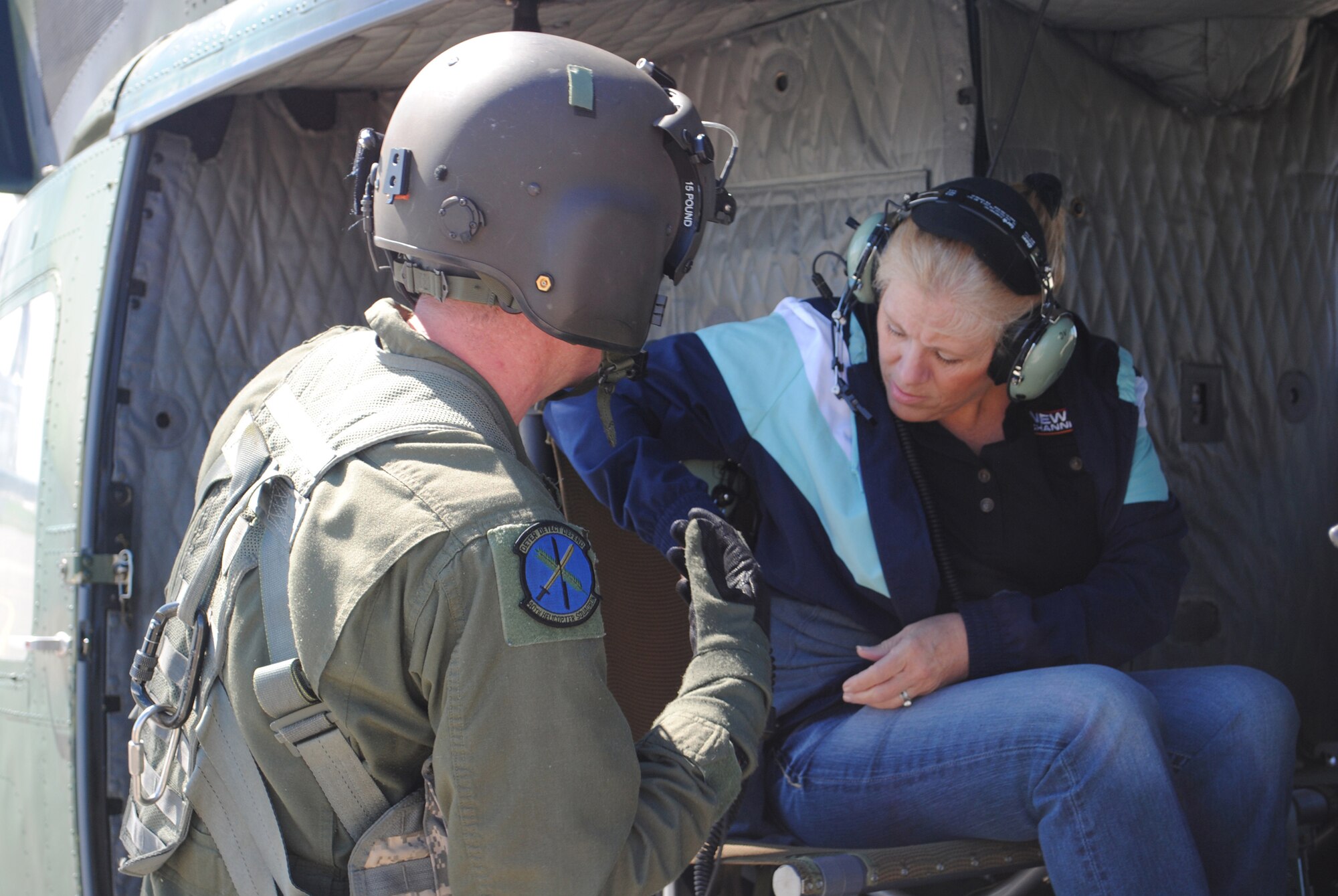 Linda Cushingham, a Military Affairs Committee member, straps herself into the helicopter with a little help from Staff Sgt. Christopher Pound, a 40th Helicopter Squadron UH-1N training assistant.  (U.S. Air Force photo/Airman Cortney Hansen)