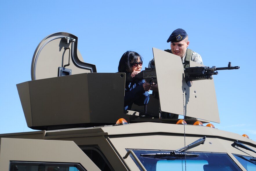Staff Sgt. James Kieffer, 741st Missile Security Forces Squadron convoy response force leader, shows Joann Gogo, a Military Affairs Committee member, the proper way to operate the weapon on the top of a Bearcat.  (U.S. Air Force photo/Airman Cortney Hansen)