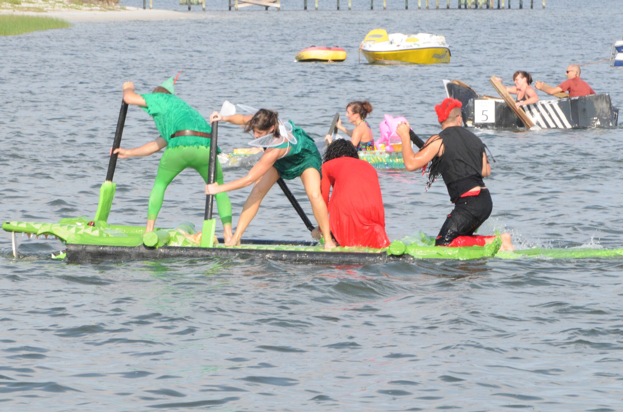 Airmen from the 1st Special Operations Component Maintenance Squadron paddle their Peter Pan-themed pontoon boat across the water during the 23rd Annual Cardboard Boat Regatta at the Marina at Hurlburt Field, Fla., July 1, 2011. The boat/van won the “Most Unique” award in this year’s race. (Courtesy photo by Barbara Fuller/Released)