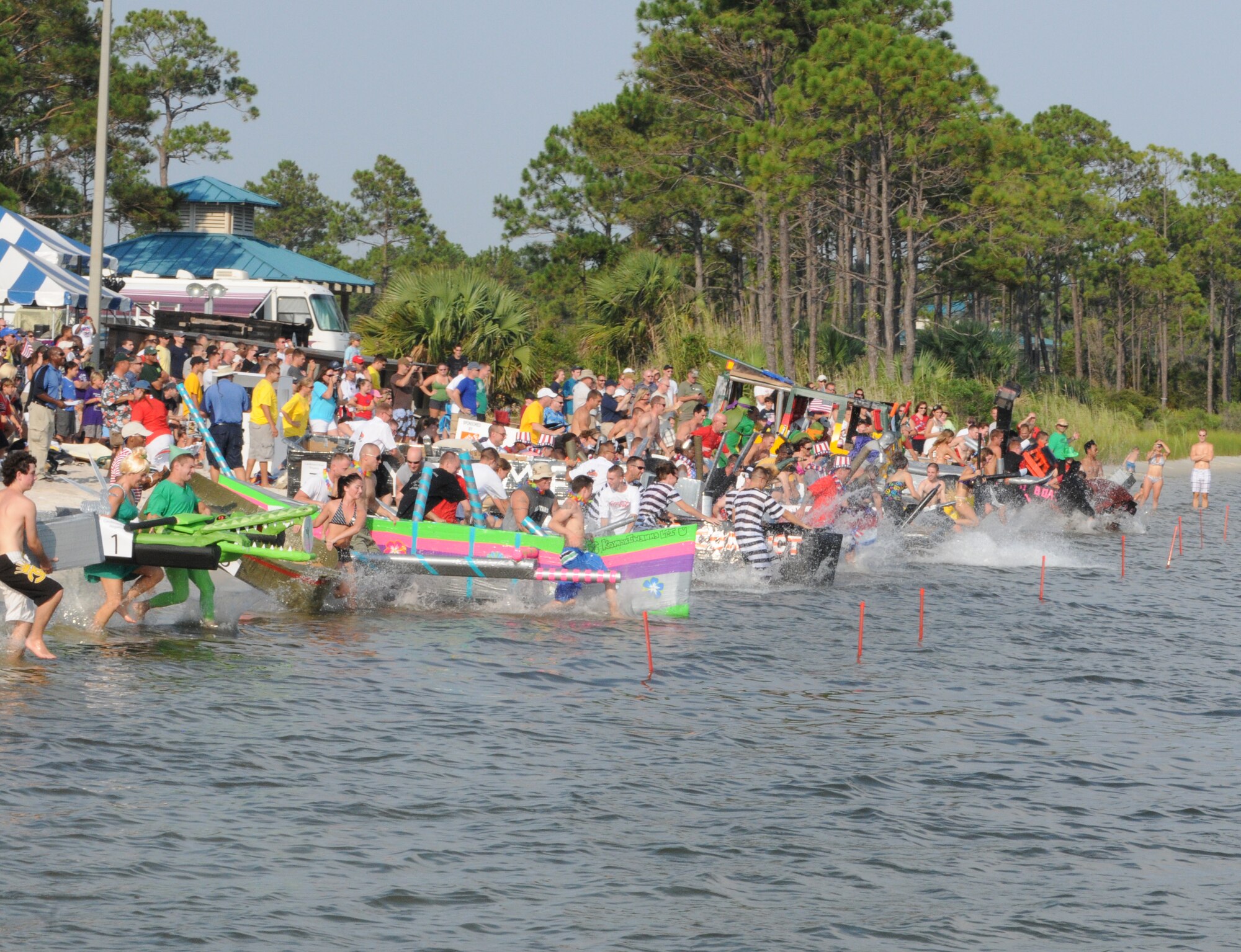 Participants rush out into the water during the start of the 23rd Annual Cardboard Boat Regatta at the Marina at Hurlburt Field, Fla., July 1, 2011. The competition allows teams to use only cardboard, glue, tape and paint to construct their makeshift vessels.  (Courtesy photo by Barbara Fuller/Released)