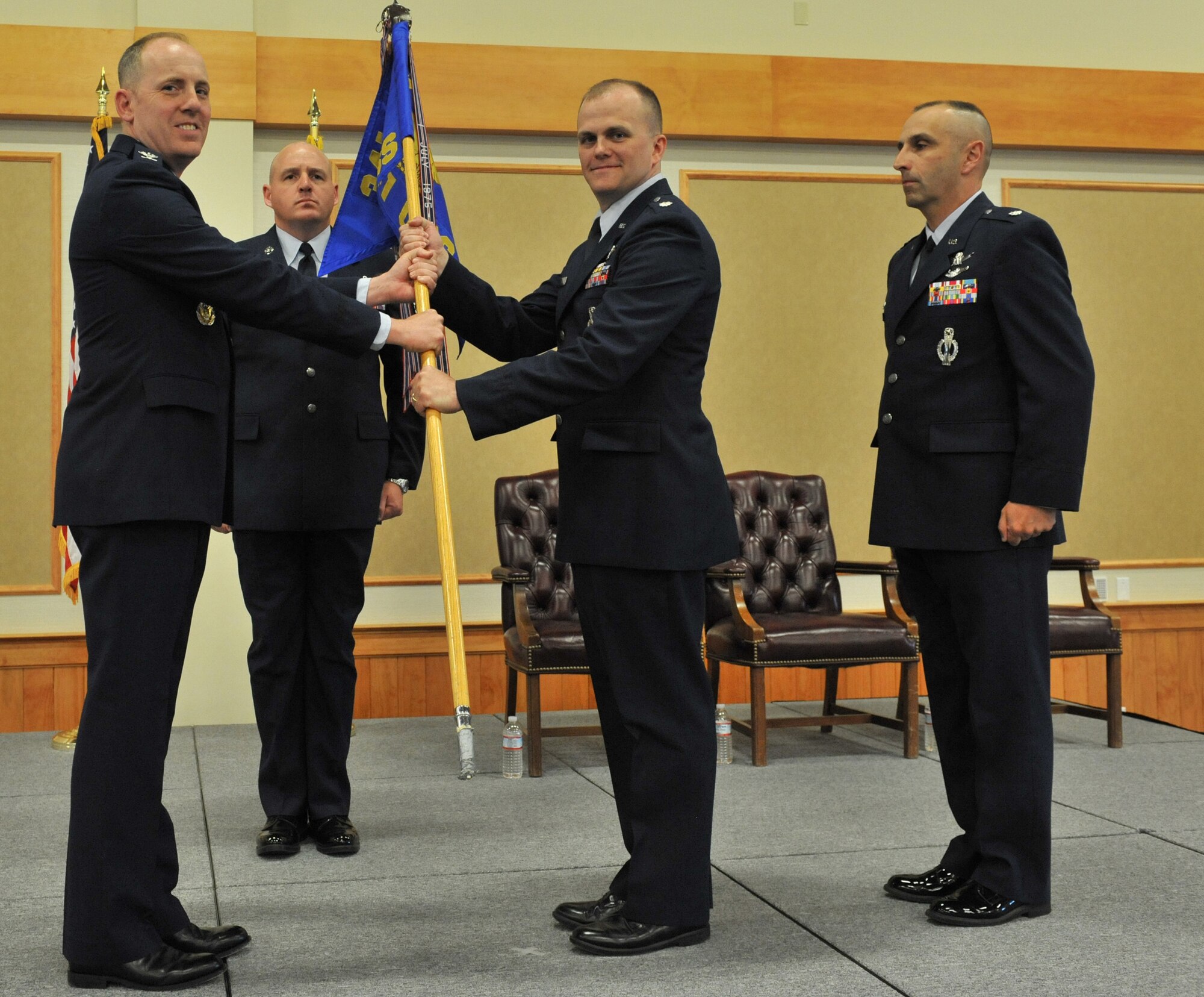 Lt. Col. Todd Sauls accepts command of the 341st Operations Support Squadron from Col. Edward Rimback, 341st Operations Group commander, June 23 at the Grizzly Bend. OG First Sergeant Master Sgt. Robert Baker and outgoing 341st OSS commander Lt. Col. Lloyd Buzzell look on. (U.S. Air Force photo/John Turner)