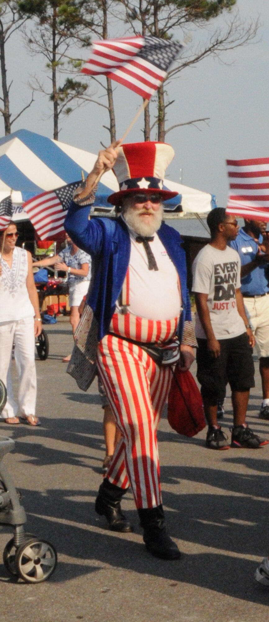 Uncle Sam waves a flag while leading a crowd in a parade during the 16th Annual Sound of Independence at the Marina at Hurlburt Field, Fla., July 1, 2011. More than 3,000 Airmen and their families enjoyed food, prizes and a fireworks extravaganza as part of the annual celebration. (Courtesy photo by Barbara Fuller/Released)