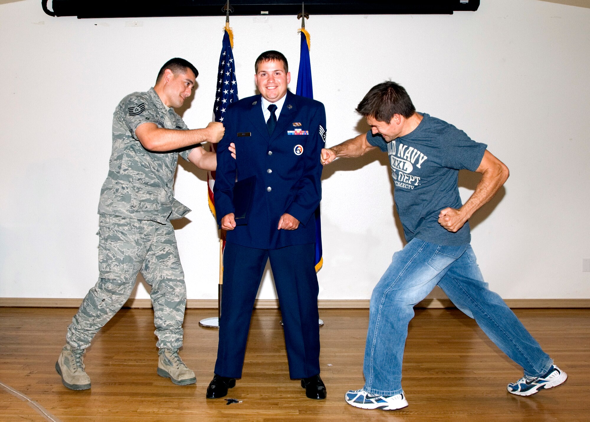 Senior Airman Justin Key, 412th Maintenance Squadron, gets help putting on his new rank of staff sergeant. Twenty-nine airmen were promoted in July's ceremony at Club Muroc, June 30. (Air Force photo by Edward Cannon)