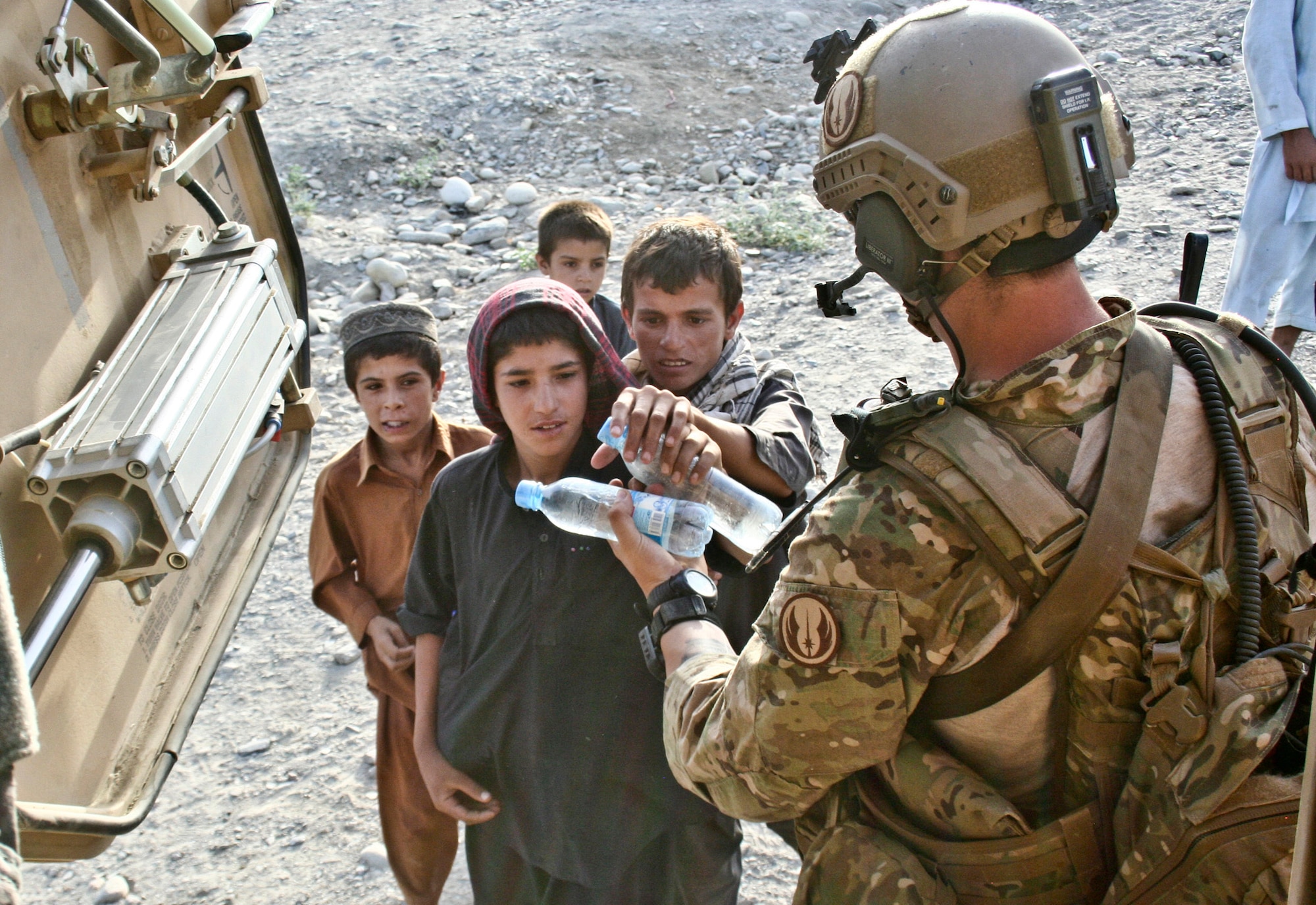 Senior Airman Michael McAffrey gives Afghan children bottles of water after completing a mission in Khanda Village in Laghman province, Afghanistan, June 18, 2011. Airman McAffrey is a joint terminal attack controller with the Washington Air National Guard's 116th Air Support Operations Squadron. (Courtesy Photo)