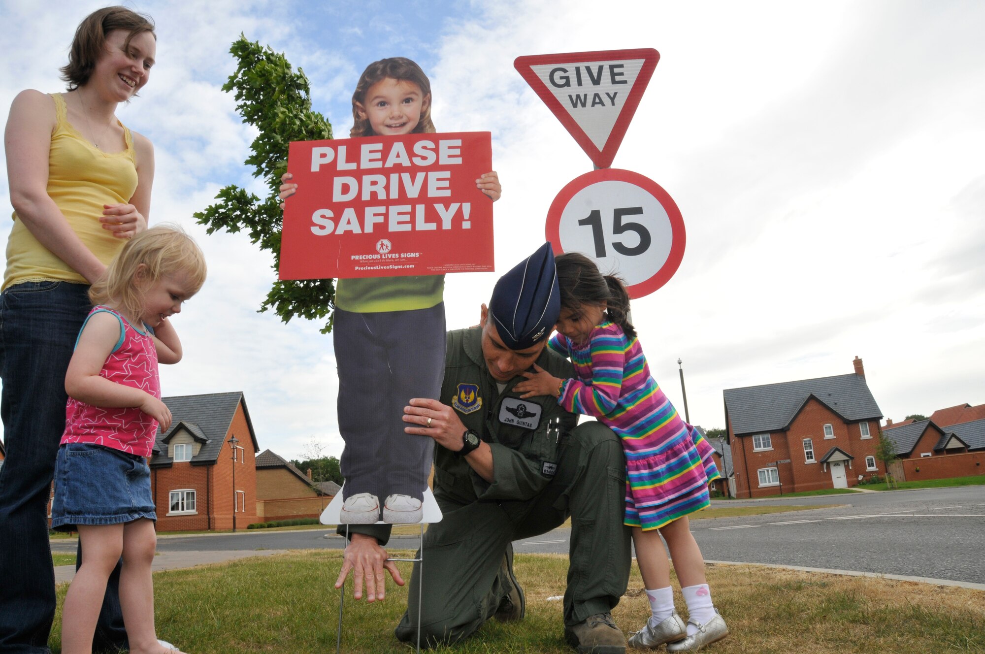 ROYAL AIR FORCE LAKENHEATH, England - Col. John Quintas, 48th Fighter Wing commander, places a safety sign in a Liberty Village yard in base housing on May 16, 2011. Airmen are reminded to drive carefully this summer and adhere to all traffic safety signs. (U.S. Air Force photo/Senior Airmen Eboni Reams)