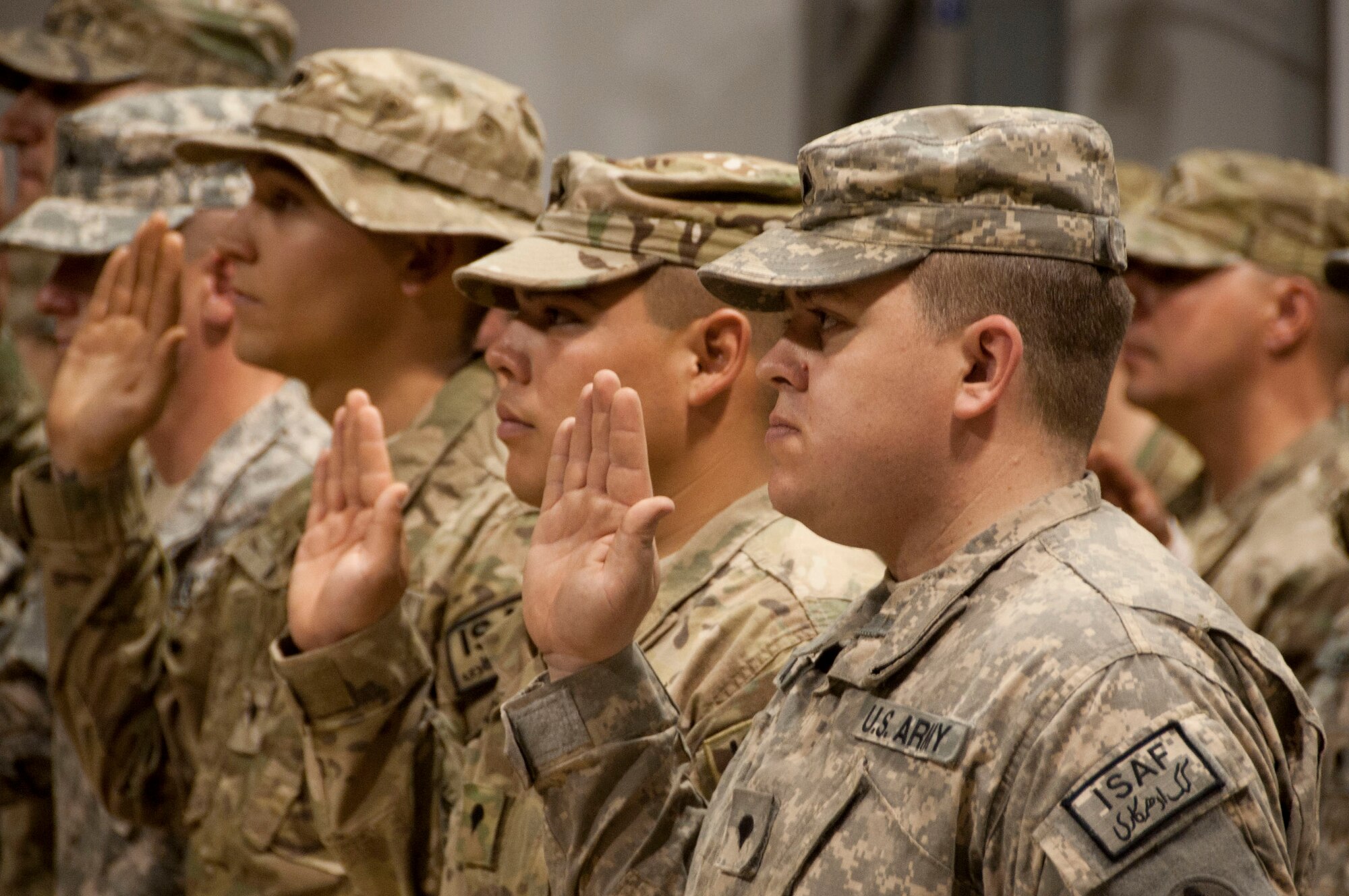 Service members re-enlist under Army Gen. David H. Petraeus's reading at Kandahar Air Field, Afghanistan, July 4, 2011. General Petraeus is the senior commander of U.S. and coalition forces in Afghanistan. (U.S. Air Force photo by Senior Airman Corey Hook)
