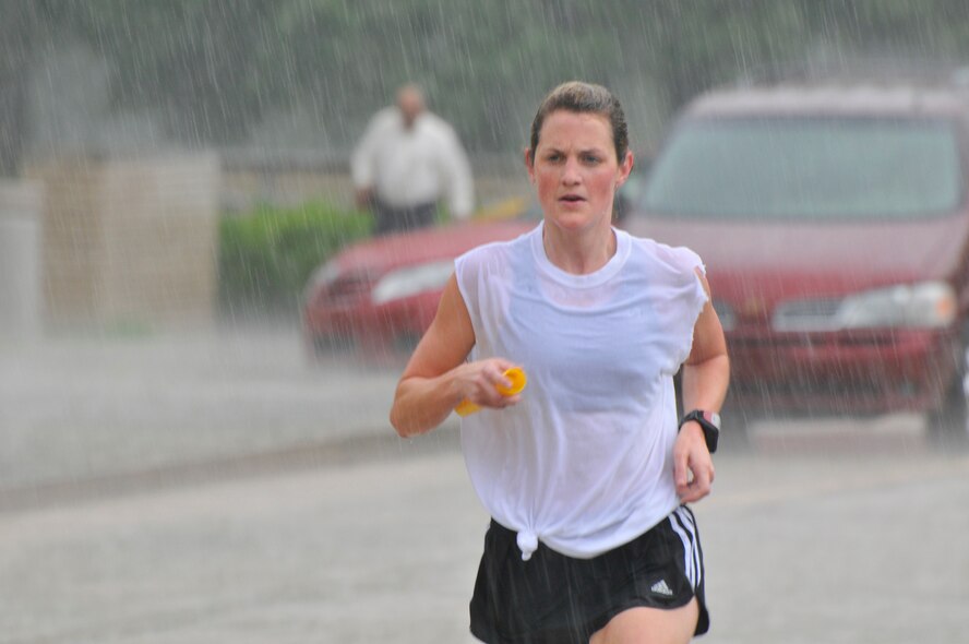 Carrie Reinholtz, a technology project manager in AEDC’s Test Technology Branch and member of The TRL’s relay team, slogs through the rain during the base’s 26th annual Golden Baton Relay Race June 22. Four teams competed in this year’s race despite pouring rain during the morning. The team Old Guys Never Quit placed first, Knights of the Dinner Table placed second, The Scream Team placed third and The TRL’s placed fourth. (Photo by Rick Goodfriend)