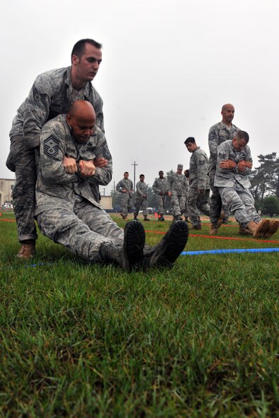 KUNSAN AIR BASE, Republic of Korea -- Airmen compete in the maneuver under fire portion of the Marine Corps Combat Fitness test here July 1. The test consisted of movement to contact; 880 yard run, 30 pound ammunition lift and the maneuver under fire, which was a 300 yard shuttle run that includes a variety of combat-related tasks, to include: crawls, buddy drags and carries, ammunition resupply, grenade throw and agility running. (U.S. Air Force photo/Senior Airman Brittany Y. Bateman)