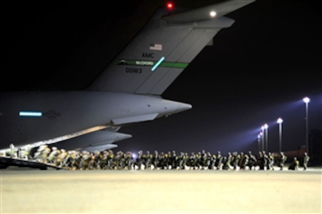 Army paratroopers prepare to board a C-17 Globemaster III aircraft before a personnel airdrop mission in support of the joint operational access exercise at Fort Bragg, N.C., on June 26, 2011.  The soldiers are assigned to the 82nd Airborne Division's 1st Brigade Combat Team.  Joint operational access exercise is a joint airdrop exercise designed to enhance service cohesiveness between U.S. Army and Air Force personnel, allowing both services an opportunity to properly execute large-scale heavy equipment and troop movement.  