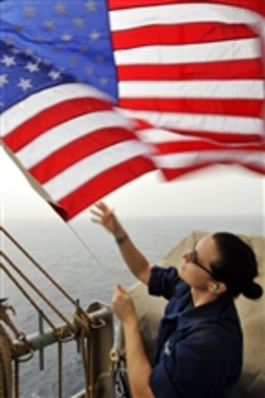 Seaman Ingrid Devinkayne sets Fourth of July colors on the weather deck of the aircraft carrier USS Ronald Reagan (CVN 76) in the Arabian Sea on July 4, 2011.  The Ronald Reagan and Carrier Air Wing 14 are deployed to the U.S. 5th Fleet area of responsibility conducting close-air support missions as part of Operation Enduring Freedom.  