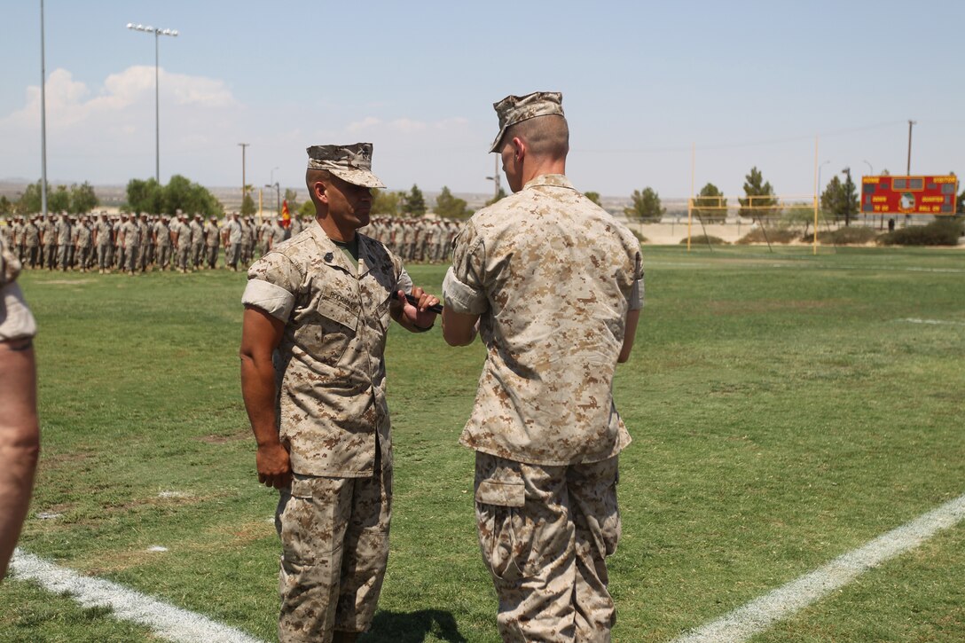 [Right] Lt. Col. Seth Folsom, the battalion commanding officer for 3rd Battalion, 7th Marine Regiment, hands Sgt. Maj. Rafael Rodriguez, the oncoming sergeant major for 3/7, a noncommissioned officer’s sword, signifying his appointment as the unit’s top enlisted Marine, during a Post and Relief Ceremony at Felix Field July 7, 2011.::r::::n::