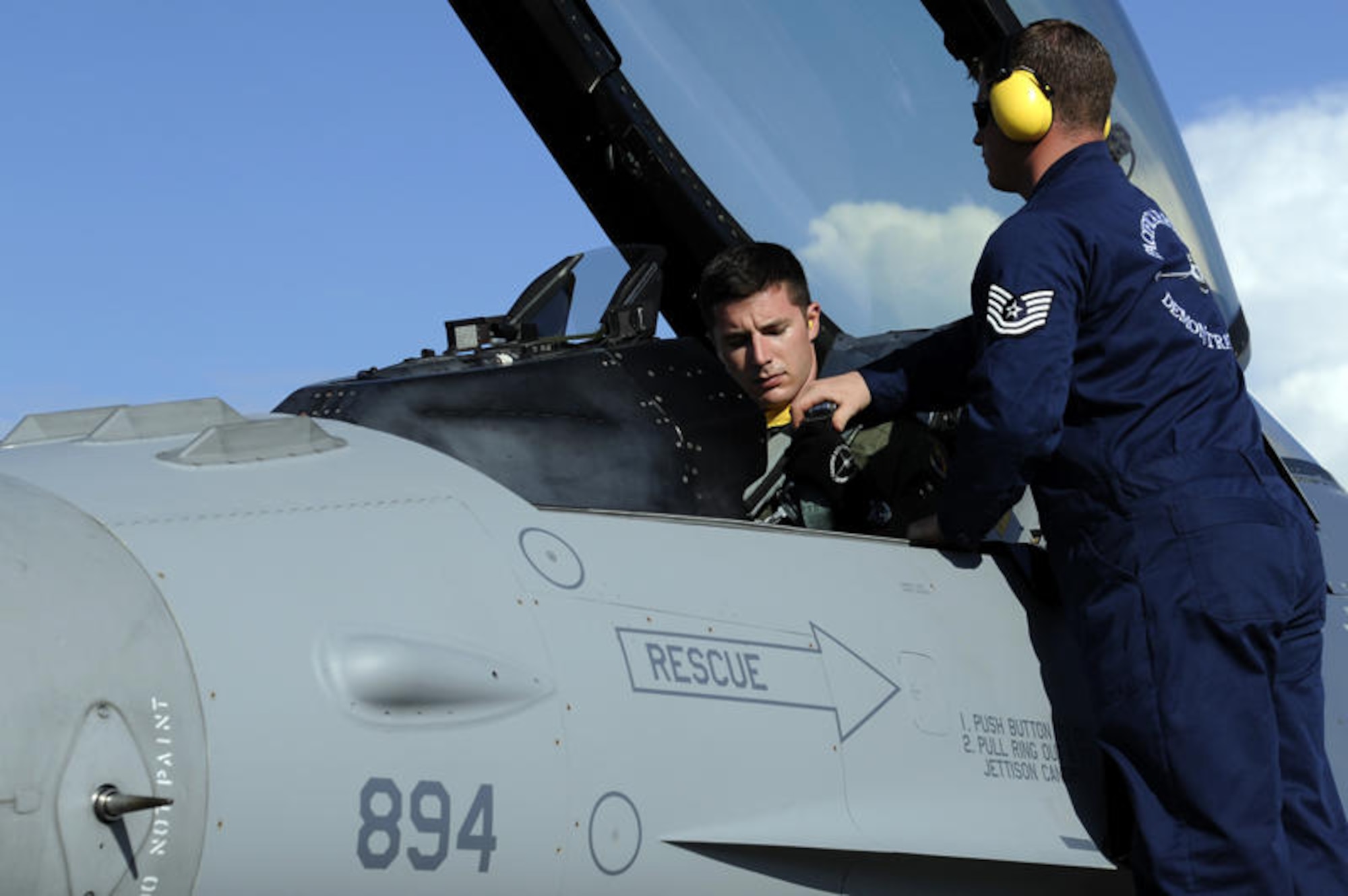 Brunei Darussalam -- Capt Chris Nations, left, Pacific Air Forces Demonstration Team pilot, and Tech. Sgt. Chad Miller, PACAF Demonstration Team crew chief, exchanges final instructions in the cockpit of a F-16 Fighting Falcon before take-off during a practice for the 3rd Biennial Brunei Darussalam International Defense Exhibition at Rimba Air Base, Brunei July 3. This is the first time that the U.S. Air Force and Pacific Air Forces have participated in this particular event and will showcase a C-17 Globemaster III and two F-16 Fighting Falcons through static displays and aerial demonstrations. (U.S. Air Force photo/Staff Sgt. Marie Brown/Released)