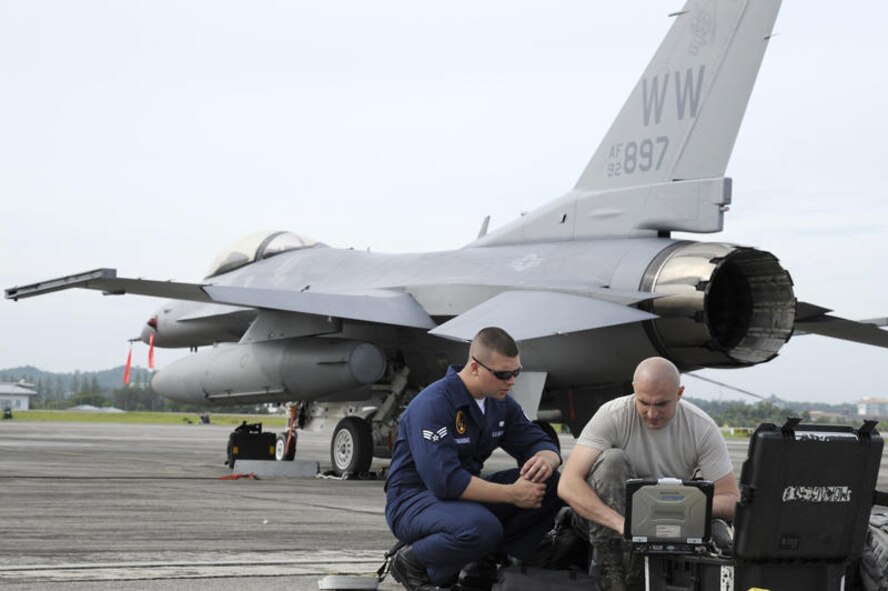 RIMBA AIR BASE, Brunei -- Senior Airman Edward Szymanski, left, Pacific Air Forces Demonstration Team member, and Staff Sgt. Jacob Cedillo, 35th Maintenance Squadron, reconciles  aircraft engine downloads of a F-16 Fighting Falcon July 2. Two F-16's along with 15 members of the 35th Fighter Wing arrived in Brunei July 1 to prepare for the 3rd Biennial Brunei Darussalam International Defense Exhibition 2011 scheduled for July 6-9. (U.S. Air Force photo/Staff Sgt. Marie Brown/Released)