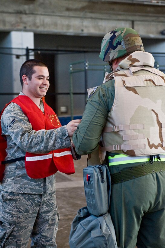 Airman 1st Class Samuel Oliver, 28th Logistics Readiness Squadron, equips members of the 28th Bomb Wing with body armor as they simulate leaving for a deployed location during a Phase I Operational Readiness Exercise at Ellsworth Air Force Base, S.D.,  June 22, 2011. Practicing the deployment process was a key objective during the Phase I ORE. (U.S. Air Force photo/Airman Alystria Maurer/Released)