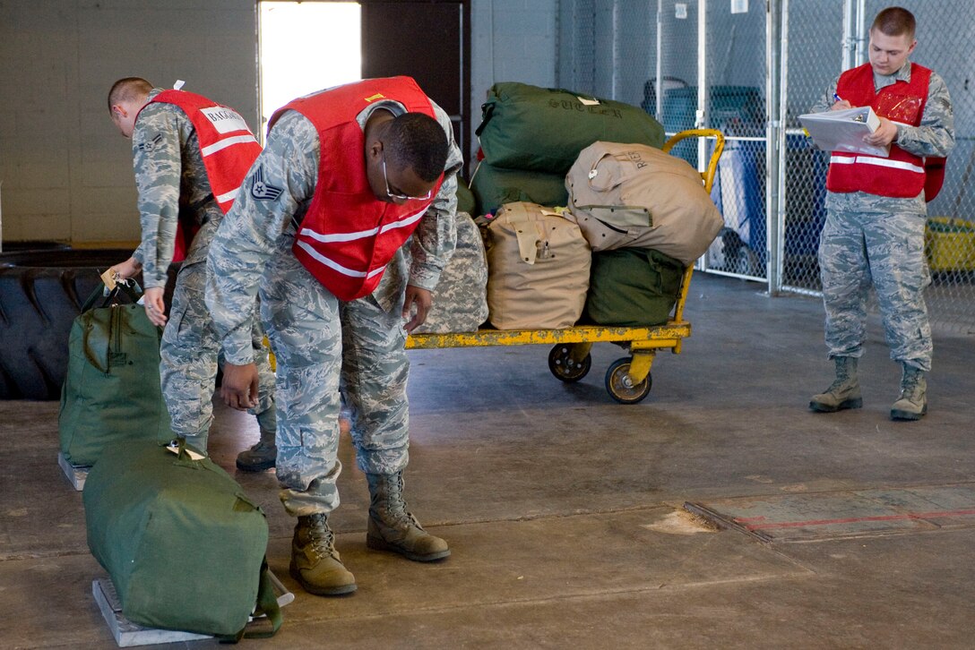 The exercise baggage team weighs and tallies bags as Airmen process through a simulated deployment line during a Phase I Operational Readiness Exercise at Ellsworth Air Force Base, S.D.,  June 22, 2011. Once the bags were weighed they will be placed on a pallet prior to being loaded onto an aircraft. (U.S. Air Force photo/Airman Alystria Maurer/Released)