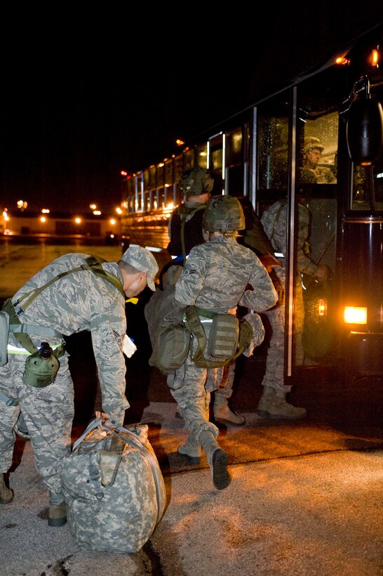 Airmen carry their bags onto a bus as they complete their portion of a Phase I Operational Readiness Exercise at Ellsworth Air Force Base, S.D.,  June 21, 2011. A portion of the ORE tested team Ellsworth’s ability to process through a simulated deployment line. (U.S. Air Force photo/Airman Alystria Maurer/Released)