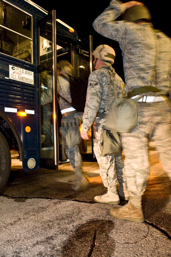 Airmen board a bus in the early morning hours during a Phase I Operational Readiness Exercise at Ellsworth Air Force Base, S.D.,  June 21, 2011. During the three day exercise, five major areas were tested, including command and control, deployment processing, sortie generation, information operations, and force protection. (U.S. Air Force photo/Airman Alystria Maurer/Released)