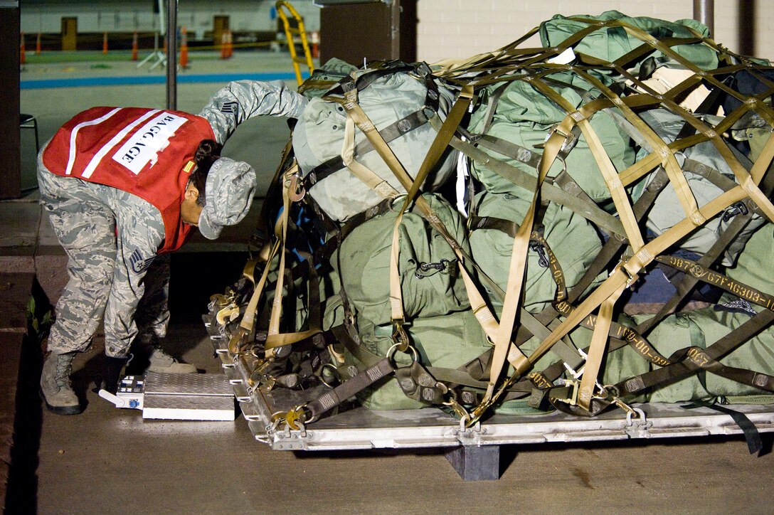 Staff Sgt. Shawnika Morris slides a scale under a pallet of duffle bags during a Phase I Operational Readiness Exercise on Ellsworth Air Force Base, S.D., June 21, 2011. During the ORE five major areas were inspected: Command and control, deployment processing, sortie generation, information operations, and force protection. (U.S. Air Force photo/Airman Alystria Maurer/Released)