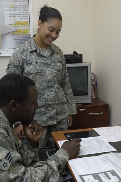 Senior Airman Chardonnay Hamilton, 92nd Logistics Readiness Squadron traffic management counselor, assists a customer with his defense personal property paperwork and briefings at the internet cafe, which opens July 8, 2011 in the Travel Management Office. (U.S. Air Force photo/ Senior Airman Natasha E. Stannard)