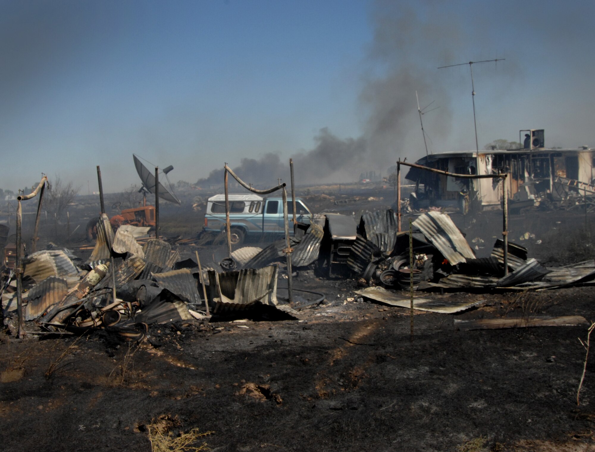 MOUNTAIN HOME AIR FORCE BASE, Idaho – A destroyed residential home smolders a few miles outside base July 6. Members of the 366th Civil Engineering Squadron responded to the fires and assisted local first responders. (U.S. Air Force photo by Senior Airman Benjamin Sutton)
