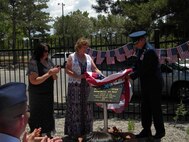 Col. Robert L. Maness, 377th Air Base Wing commander, right, and Shirley Tetreault, New Mexico Garden Clubs Inc. president, center, unveil a Blue Star Memorial July 3 at the Albuquerque Garden Center, while Debi Harrington, Uptown Garden Club president, observes. The blue star represents all men and women who have served in the armed forces of the United States. U.S. Air Force Photo by Dennis Carlson