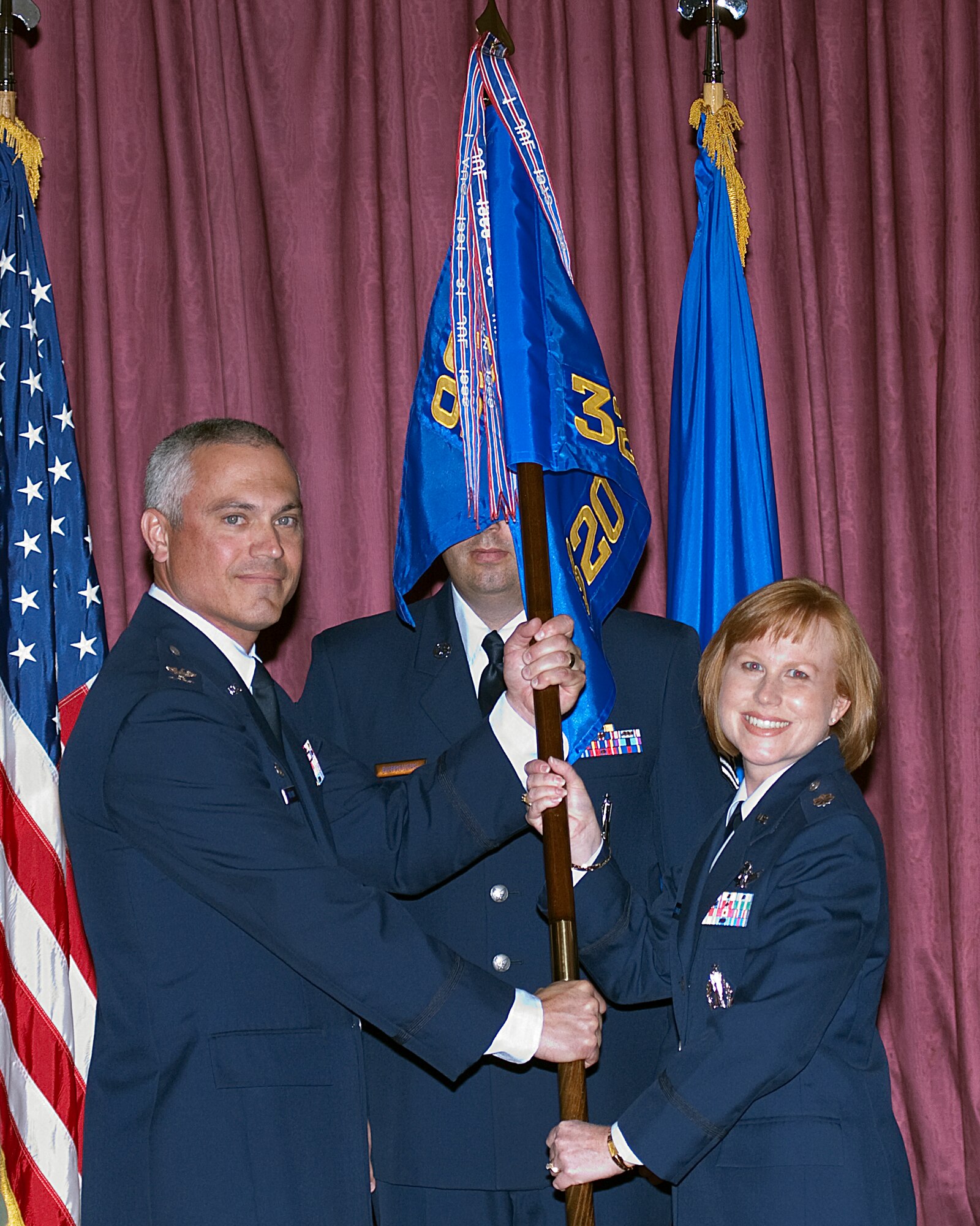 Lt. Col.Anita Feugate Opperman, 320th Missile Squadron commander, accepts the guidon from Col. Robert Vercher, 90th Operations Group commander, during the 320th MS change-of-command ceremony at the Trail’s End Club Tuesday. (U.S. Air Force photo by Blaze Lipowski)