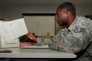 Staff Sgt. Soloman Jones, 633rd Aeromedical Squadron health service manager, picks out a Saint Leo University registration form at the Education Center at Langley Air Force Base, Va., July 7, 2011. The Education Center provides classes from various colleges and universities to assist servicemembers in obtaining their Community College of the Air Force or civilian degree. (U.S. Air Force photo by SSgt Ashley Hawkins/Released)