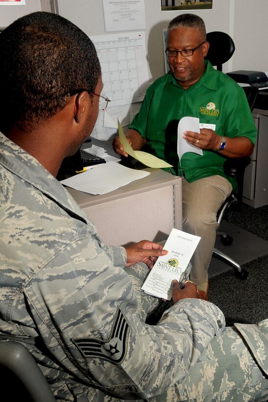 Staff Sgt. Leonard Pierce, 440th Supply Chain Operations Squadron funds manager, receives advice from Saint Leo University academic advisor, Albert Brooks, at the Education Center at Langley Air Force Base, Va., July 7, 2011. The education center personnel assist military members with obtaining various degrees from many colleges by giving one-on-one classes or simply giving advice. (U.S. Air Force photo by SSgt Ashley Hawkins/Released)