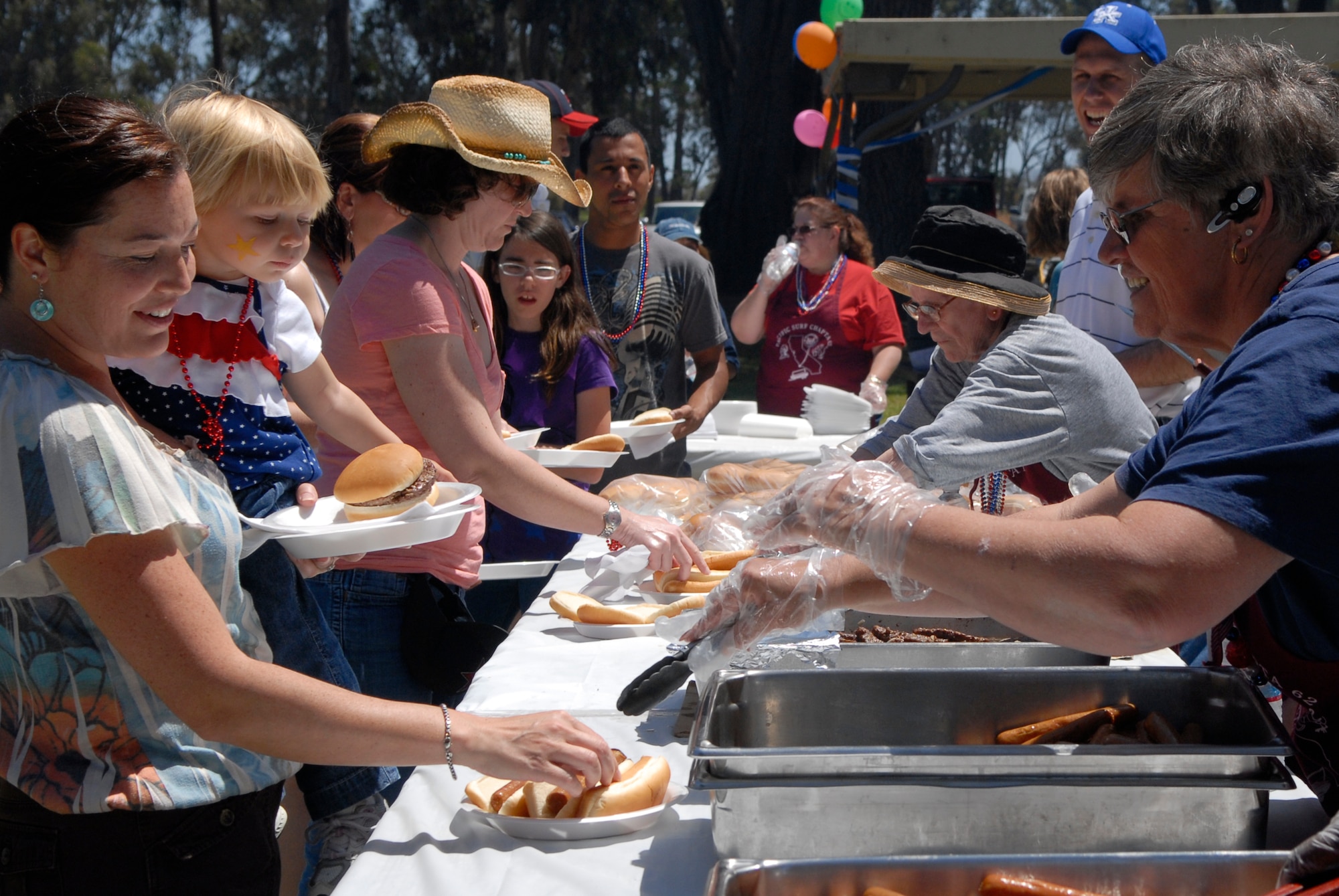 VANDENBERG AIR FORCE BASE, Calif. -- Team V members get their hamburgers and hot dogs during an Independence Day picnic at Cocheo park here Saturday, July 2, 2011.  (U.S. Air Force photo/Staff Sgt. Andrew Satran) 

  