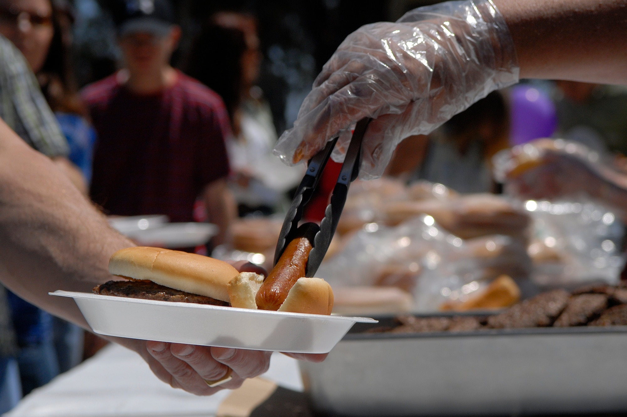 VANDENBERG AIR FORCE BASE, Calif. -- A Team V member gets a hot dog during an Independence Day picnic at Cocheo park here Saturday, July 2, 2011.  (U.S. Air Force photo/Staff Sgt. Andrew Satran) 

 