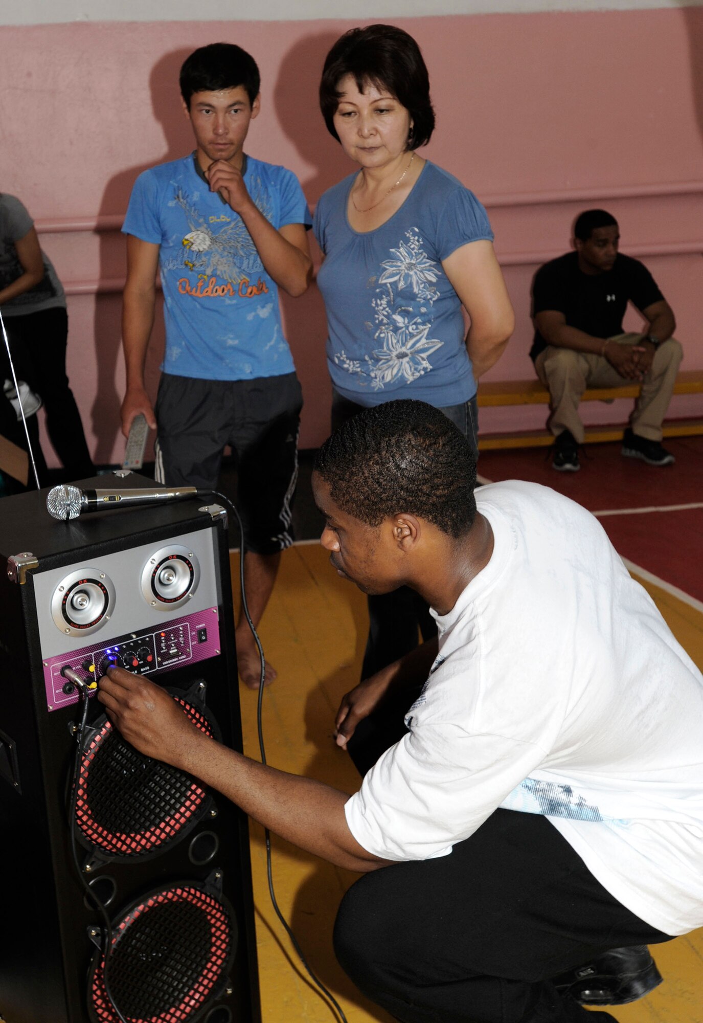 Staff Sgt. Diamond Edwards demonstrates how to use a public address system July 1, 2011, the that 376th Expeditionary Communications Squadron donated to the school in Kamyshanvka, Kyrgyzstan. Airmen from the Transit Center at Manas spent the afternoon visiting with the village mayor and school staff and playing games with the students. Edwards is a communications project manager. (U.S. Air Force photo/Tech. Sgt. Tammie Moore)