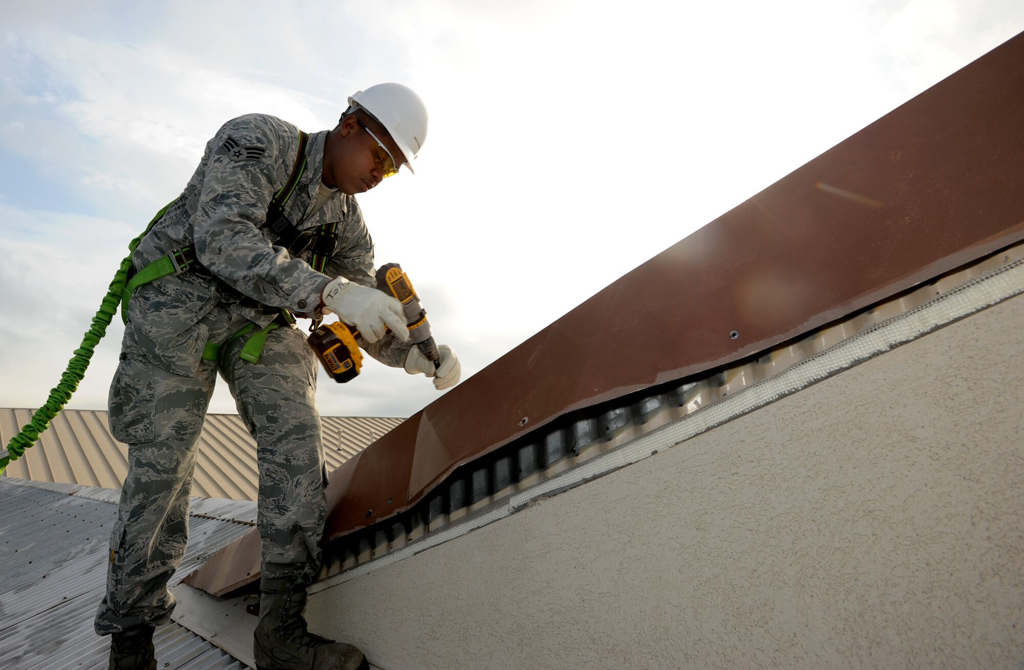 Senior Airman Tommy Rhodes, 22nd Civil Engineer Squadron structures journeyman, replaces metal flashing on the roof that was damaged by strong winds on building 1108 July 7, 2011, McConnell Air Force Base, Kan.  The St. Louis, Mo., native maintains, repairs and fabricates structures on base. (U.S. Air Force photo/ Airman 1st Class Laura L. Valentine)