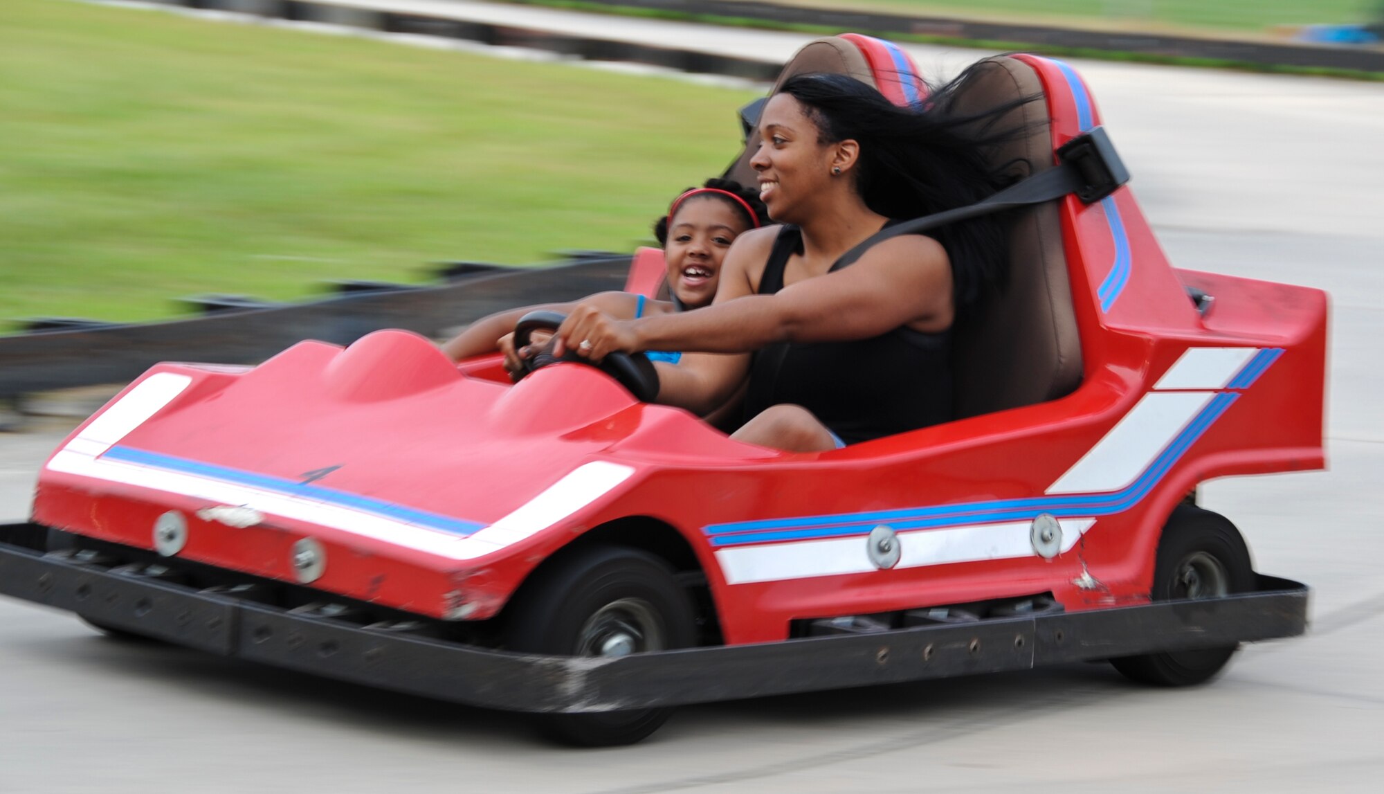 JOINT BASE MCGUIRE-DIX-LAKEHURST, N.J. – Mother, Angel Thompson, and daughter, Makayla, ride go-carts during the annual Fourth of July celebration on Dix. The entertainment included bouncy castles, putt-putt golf and live performances from The Billy Walton Band. (U.S. Air Force photo by Senior Airman David Carbajal/Released)