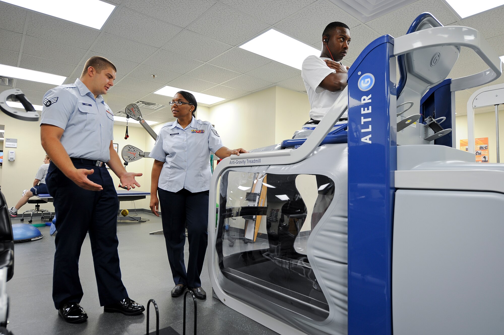 SEYMOUR JOHNSON AIR FORCE BASE, N.C. – Physical therapy technician Senior Airman Randy Slaba talks with medical services flight chief and licensed practical nurse Tech. Sgt. Nina Anderson, both from the 4th Medical Operations Squadron, about the new Alter-G Anti-Gravity Treadmill here June 20, 2011. Senior Airman Robert Glenn, 567th Red Horse Squadron, also cools down on the treadmill during a physical therapy session for his injured ankle. The treadmill prevents injury by filling with air around the body to reduce impact on the joints. Slaba hails from North Platte, Neb. and Anderson hails from Fayetteville. (U.S. Air Force photo by Tech. Sgt. Colette M. Graham/Released)