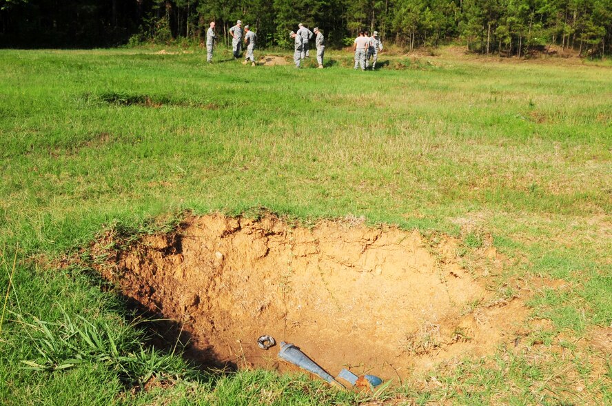 Second Bomb Wing leadership and members of 2nd Civil Engineer Squadron Explosive Ordinance Disposal unit survey damage after watching a bomb demonstration on an EOD range located on Barksdale Air Force Base, La., July 5. The demonstration not only informed base leadership about EOD procedures, it allowed EOD personnel to get their monthly range qualification. (U.S. Air Force photo/Senior Airman Joanna M. Kresge) 