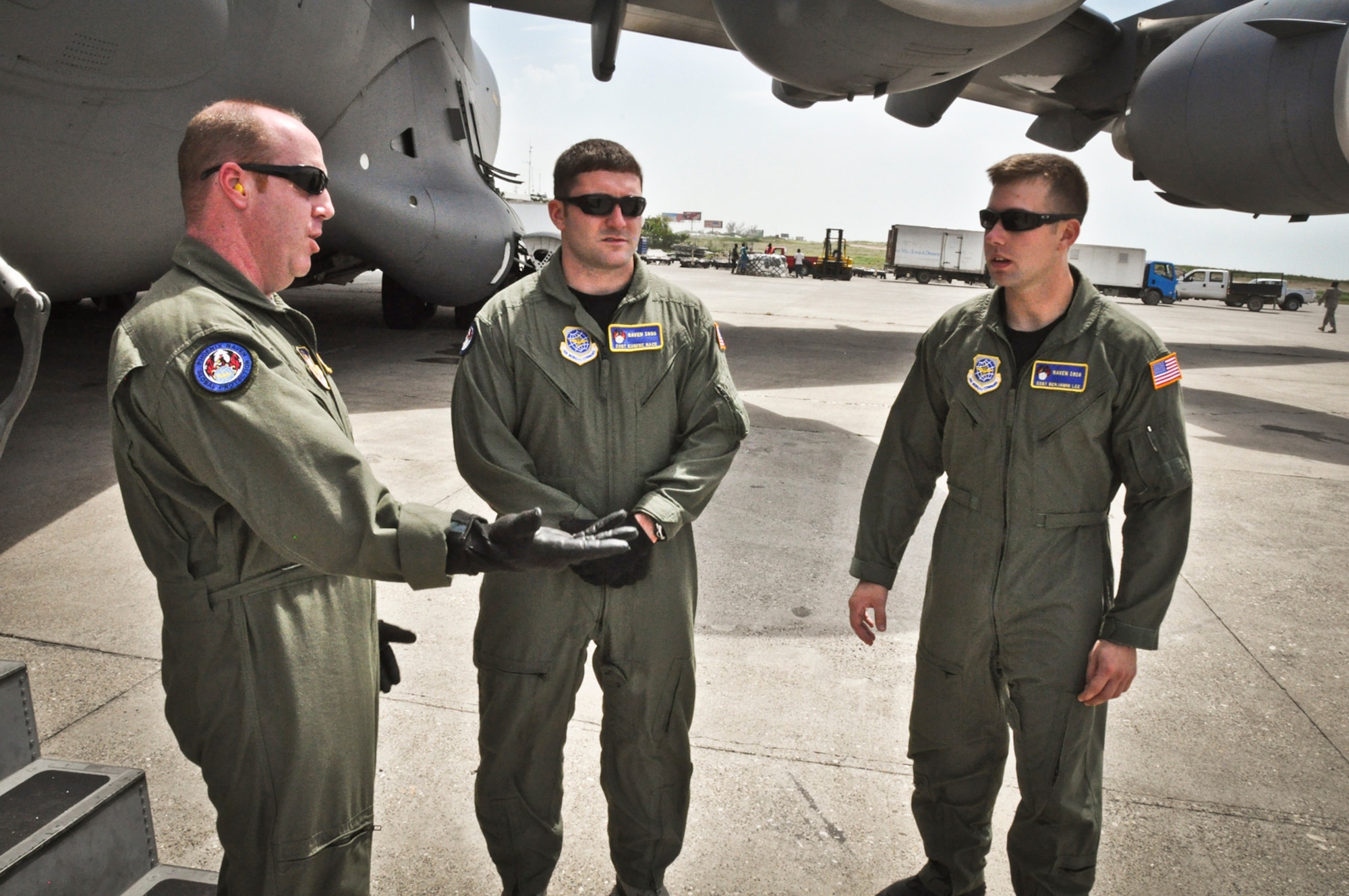 Technical Sergeant Steven Smith (left) conducts a mission debriefing with Staff Sergeant's Eugene Nace (middle) and Benjamin Lee (right) after a security stand-by during a humanitiarian aid mission to the island of Haiti on July 1, 2011. All three airmen are memebers of the Air Forces elite "Phoenix Raven" program. (U.S. Air Force photo by Staff Sgt. Rashard Coaxum)