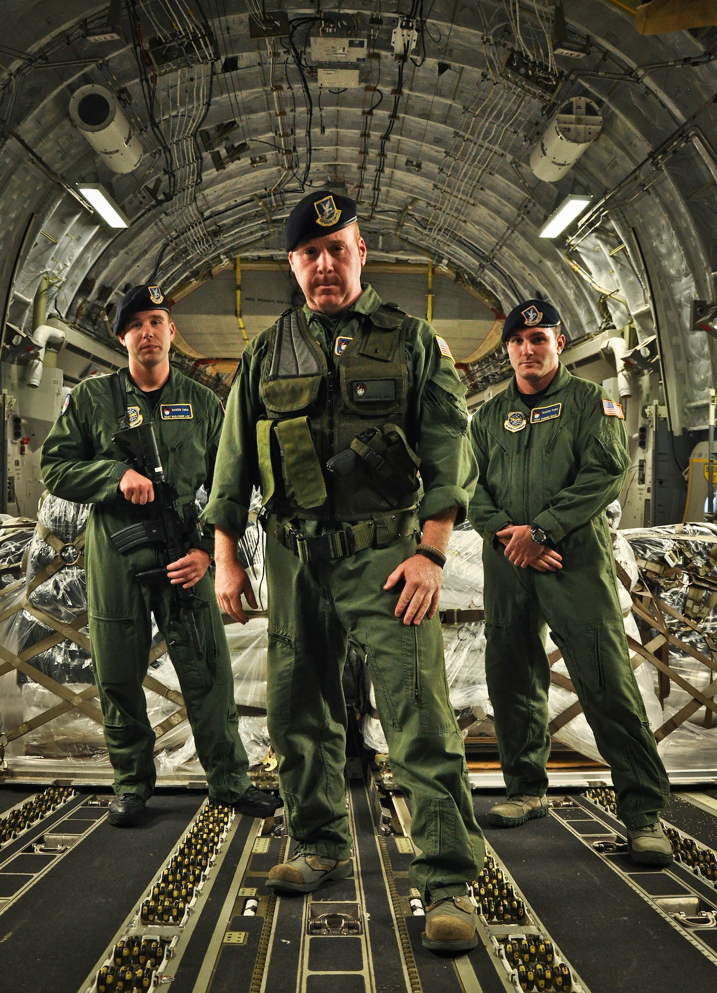 Tech. Sgt. Steven Smith (middle) stands with Staff Sgt. Benjamin Lee (left) and Staff Sgt. Eugene Nace (right) aboard a C-17 Globemaster III bound for Haiti. The airmen are members of the Air Force's elite "Phoenix Raven" program which tasks Ravens to fly with aircraft on missions that fly into hostile territories. (U.S. Air Force photo by Staff Sgt. Rashard Coaxum)