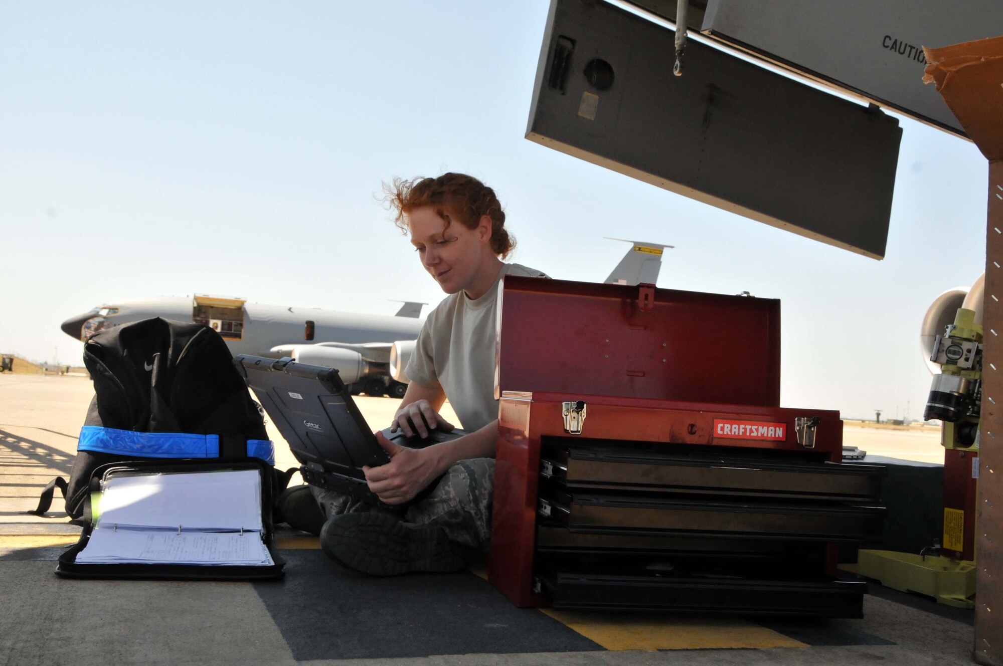 Airman 1st Class Zina R. Allred reads technical data to Senior Airman Joseph Moran (not pictured) while replacing an antenna pedestal of the color weather radar on a KC-135 Stratotanker at the 313th Air Expeditionary Wing on July 5, 2011, in Western Europe.
