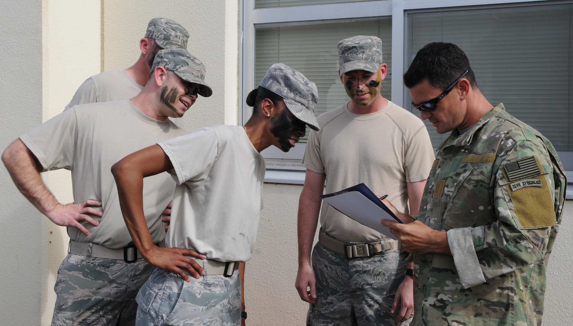 KADENA AIR BASE, Japan -- Tech Sgt. Michael Comley, a Survival, Evasion, Resistance and Escape specialist with the 353rd Special Operations Support Squadron, checks a team’s answers at a station of an obstacle course during a visit to the 353rd Special Operations Group here July 6. The 353rd SOG hosts students of the Erwin Professional Military Education Center's NCO Academy Air Commando Flight each class. (U.S. photo by Tech. Sgt. Aaron Cram)