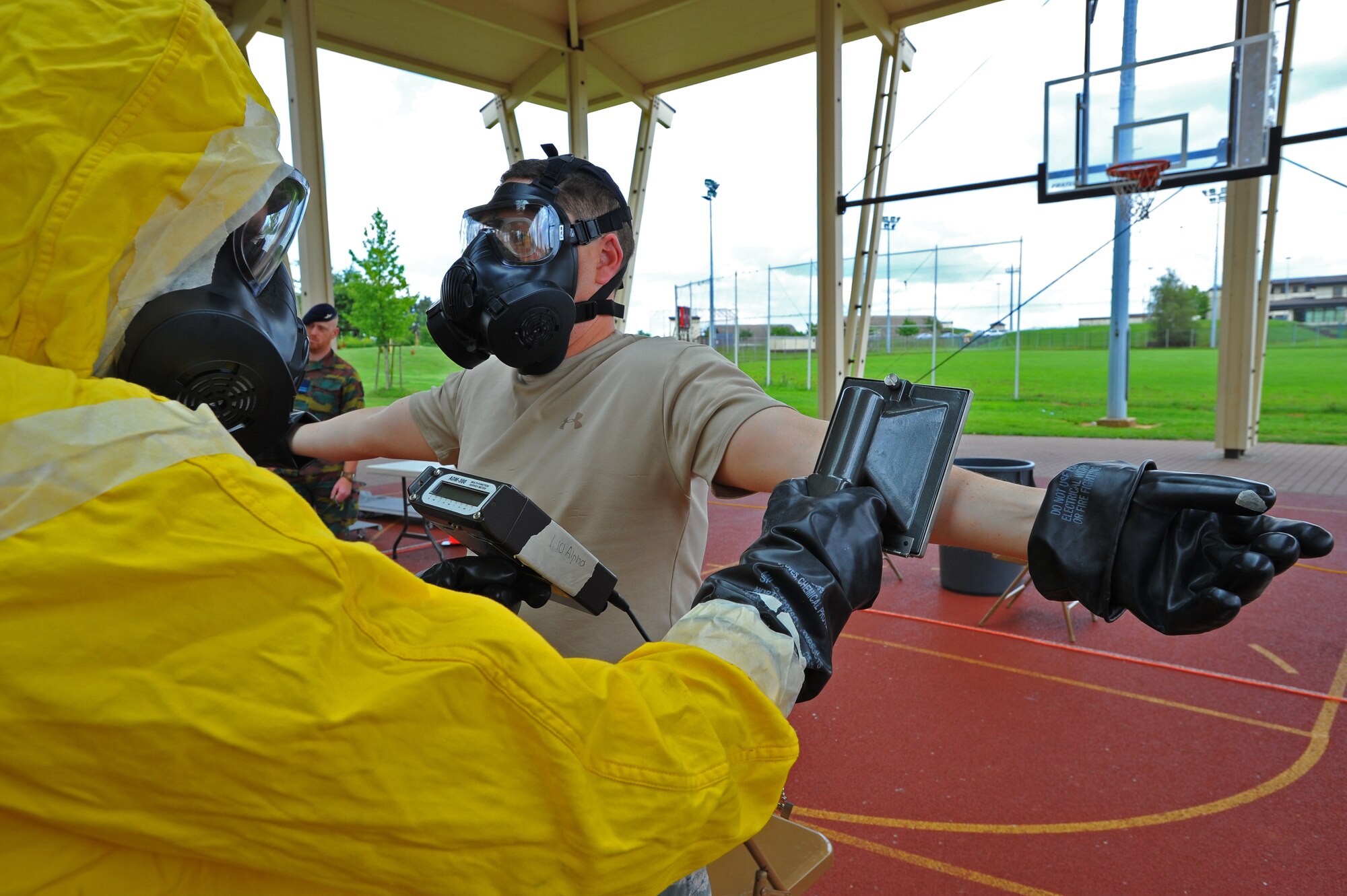 SPANGDAHLEM AIR BASE, Germany – Airmen assigned to the 52nd Civil Engineer Squadron simulate scanning one another for alpha and beta radiation during a decontamination exercise here June 30. Members of the Belgian air force visited to learn about U.S. Air Force decontamination procedures. (U.S Air Force photo/Airman 1st Class Dillon Davis)